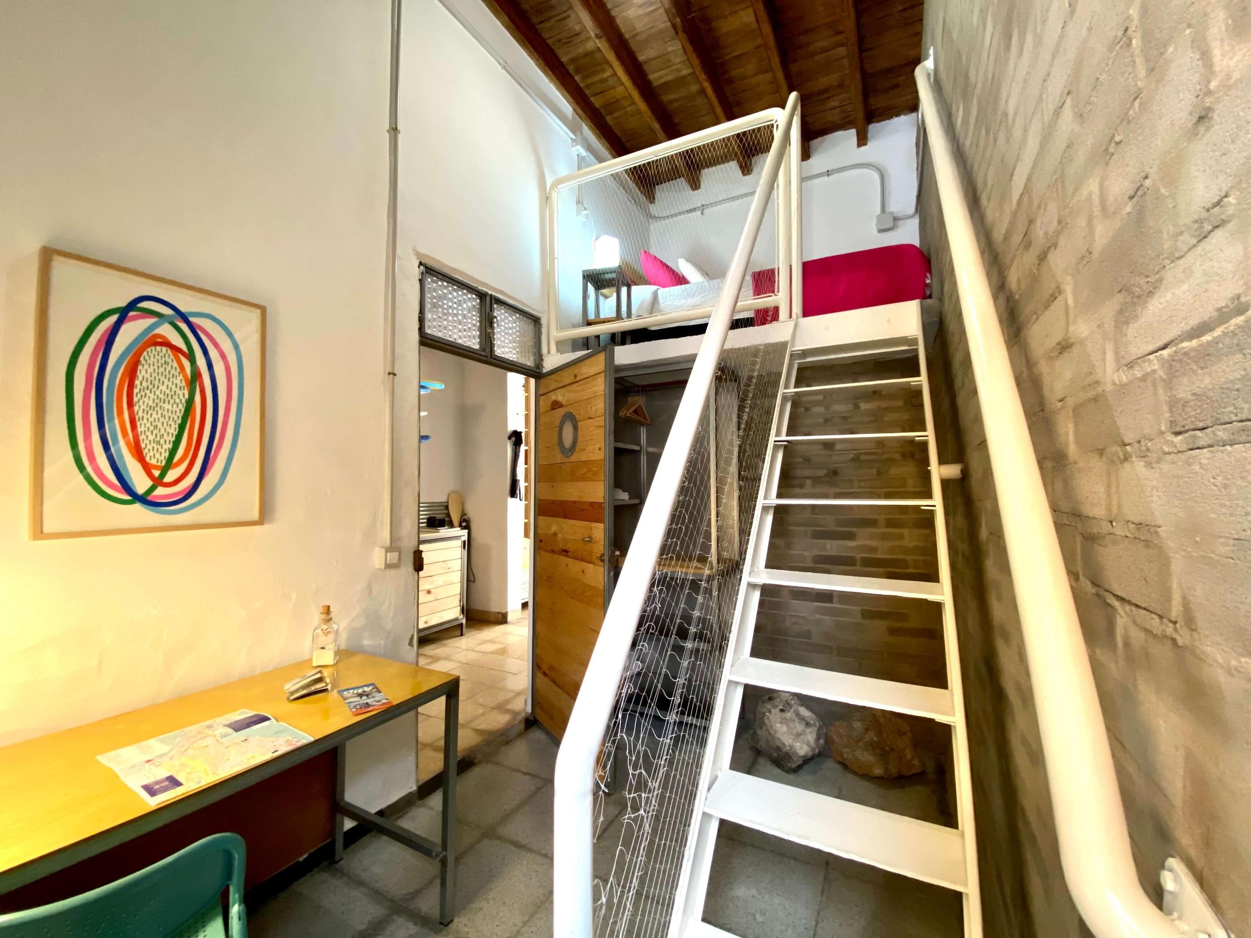 Cozy single room in a Coliving in Gran Canaria, with a single bed and desk inside of the room. Decoration by a local artist