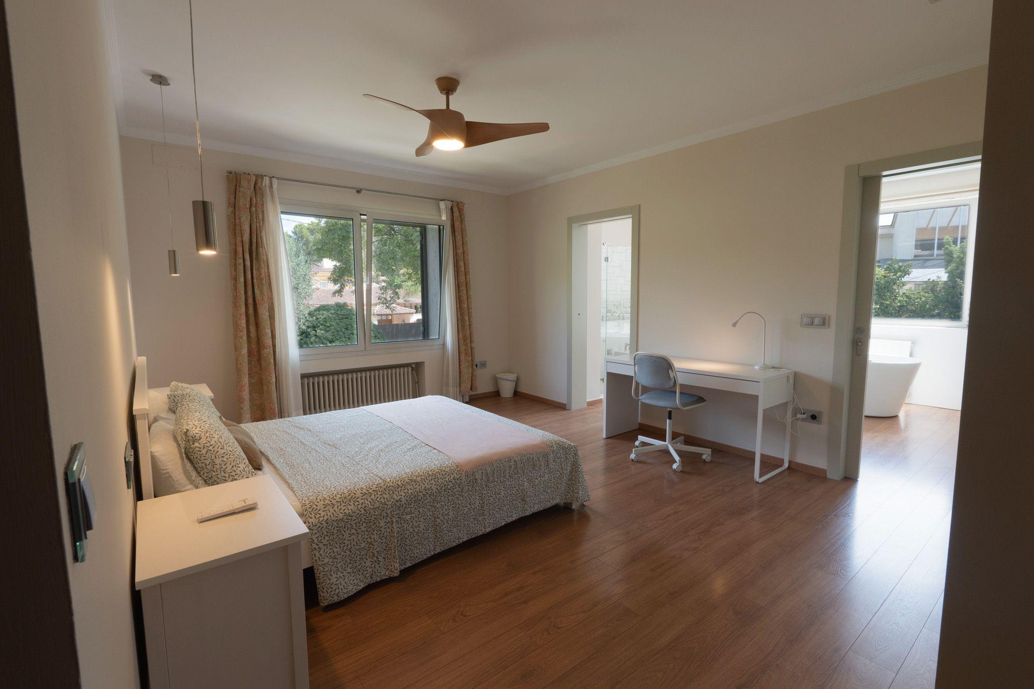 XL Kingston room showing bed, workspace, ceiling fan and ensuite bathroom entrance