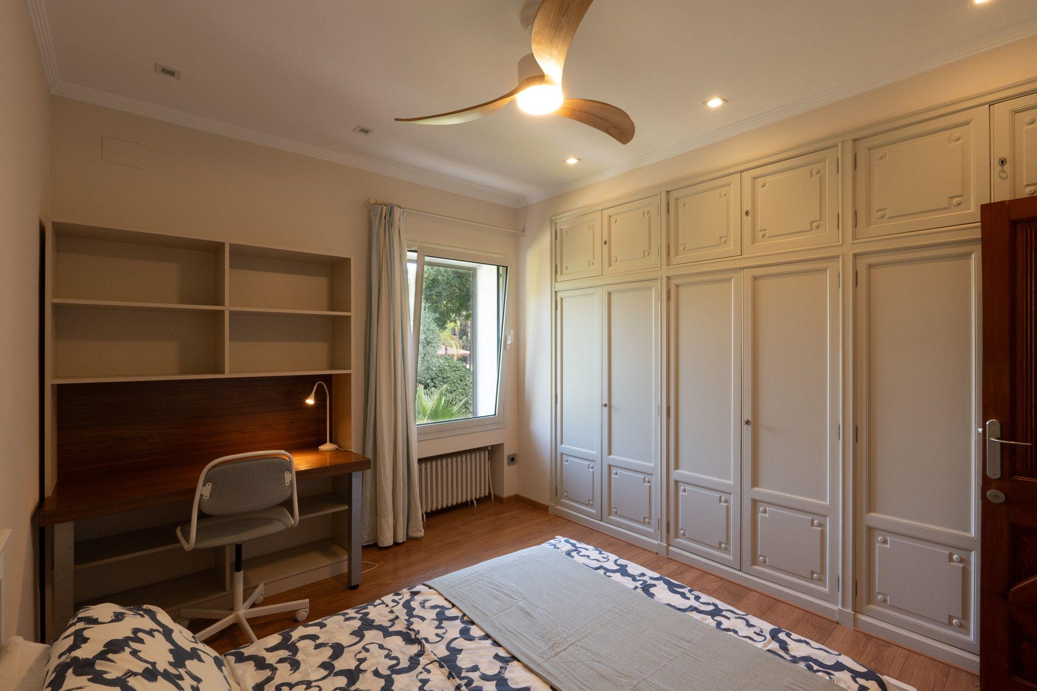 Alginet room showing bed, fitted wardrobes and ceiling fan