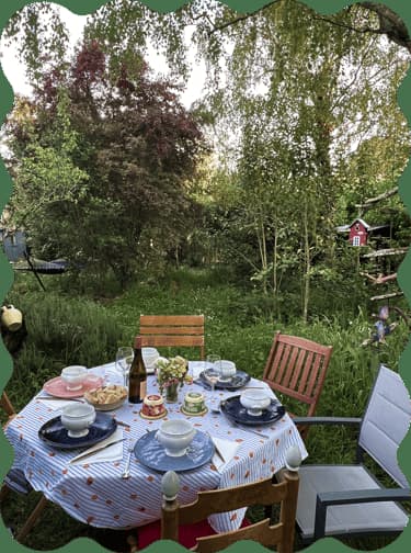 Table set for a meal surrounded by garden greenery