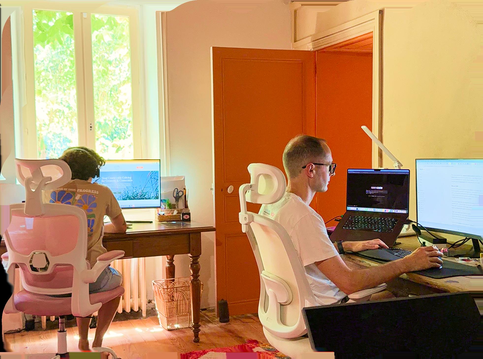 Coworking desks by the window with two people working on laptops