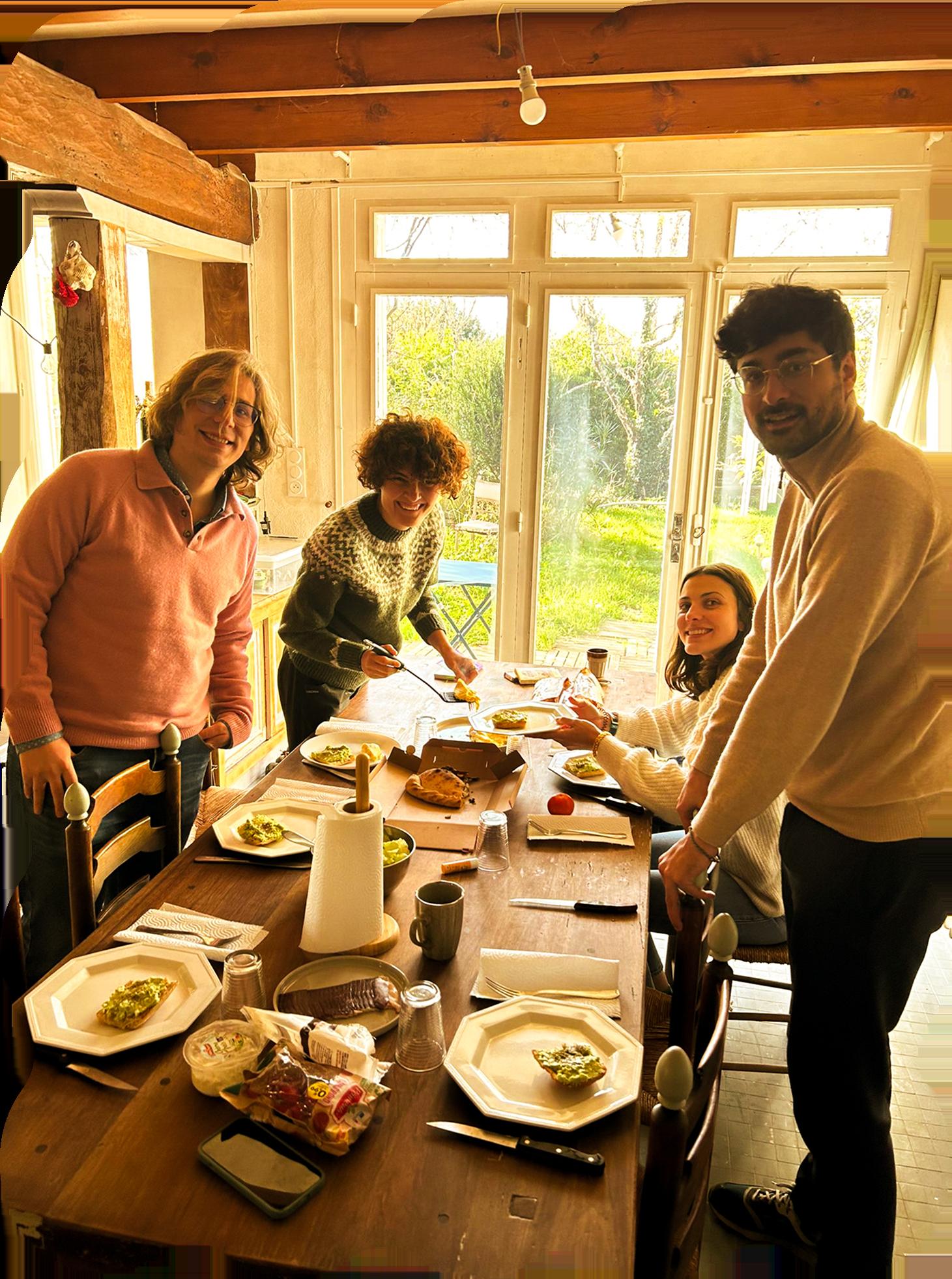Group of colivers gathered around dining table sharing a meal