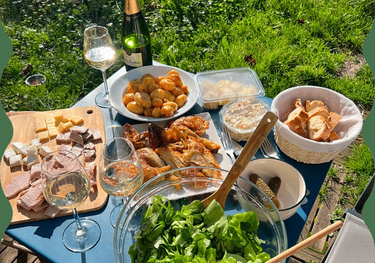 Picnic food and wine spread on a garden table