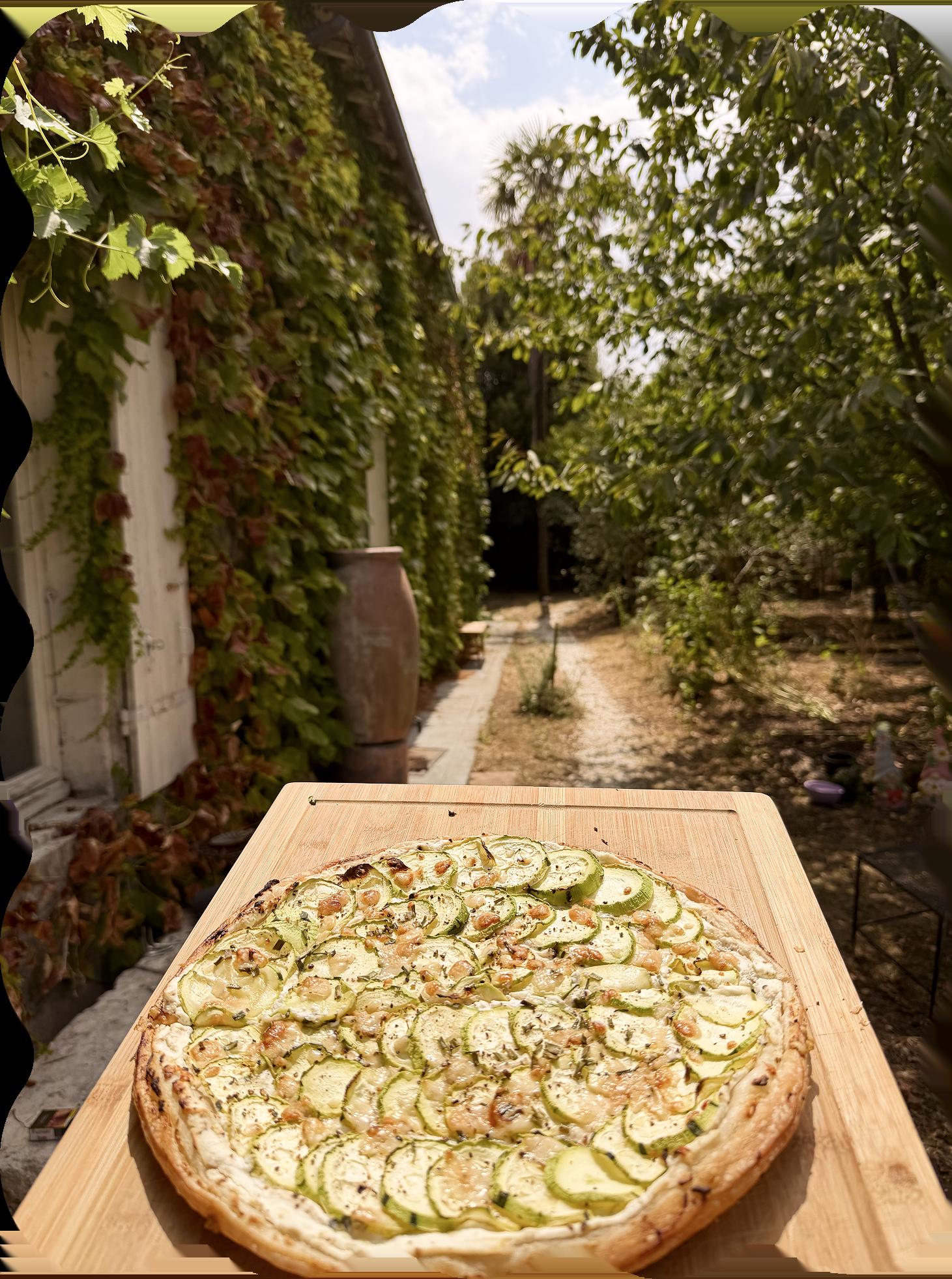 Homemade zucchini tart on a wooden board in the garden pathway