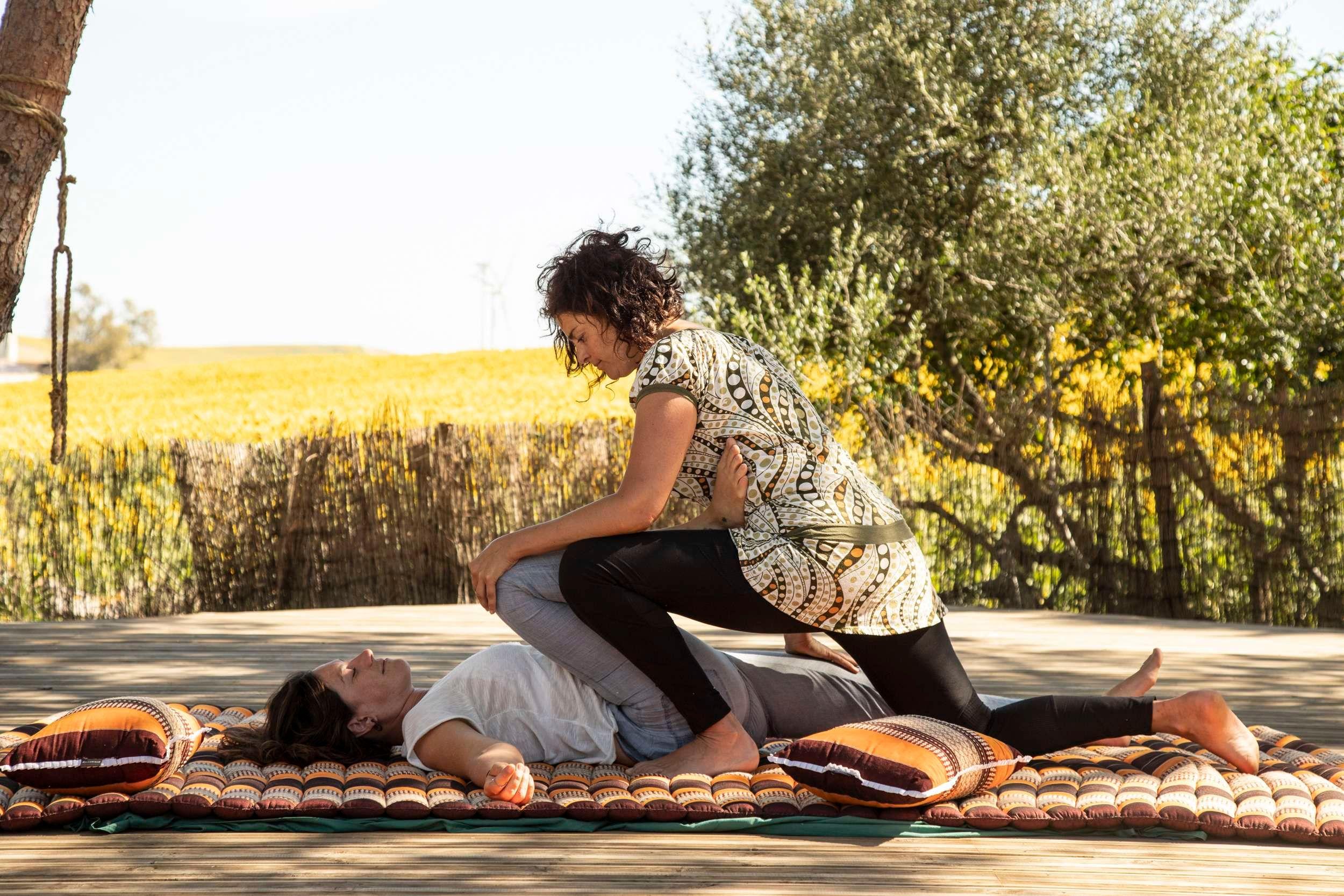 2 women on a colourful matt giving/receiving a shiatsu massage
