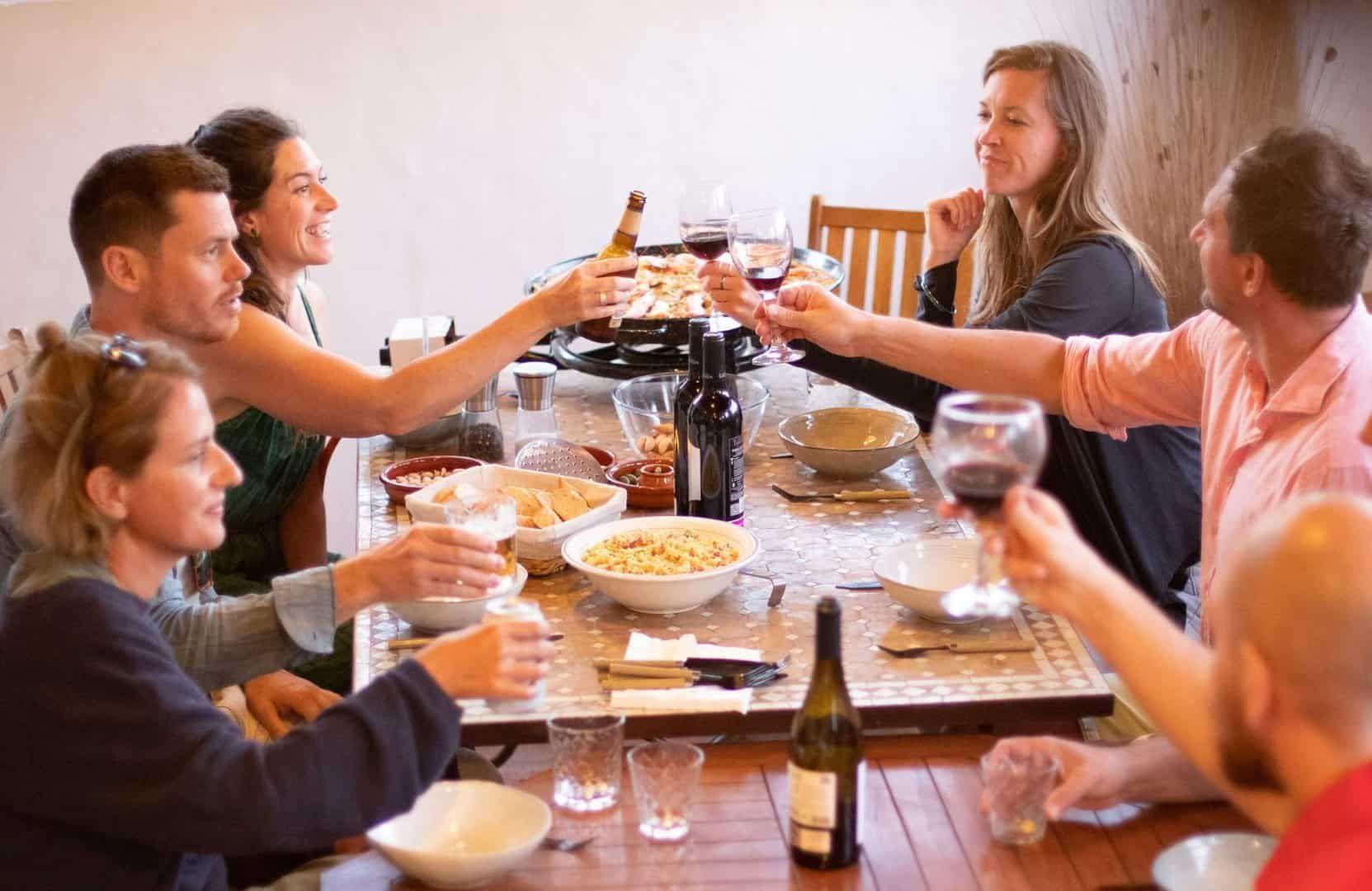 6 people sitting on a table with food and drinks