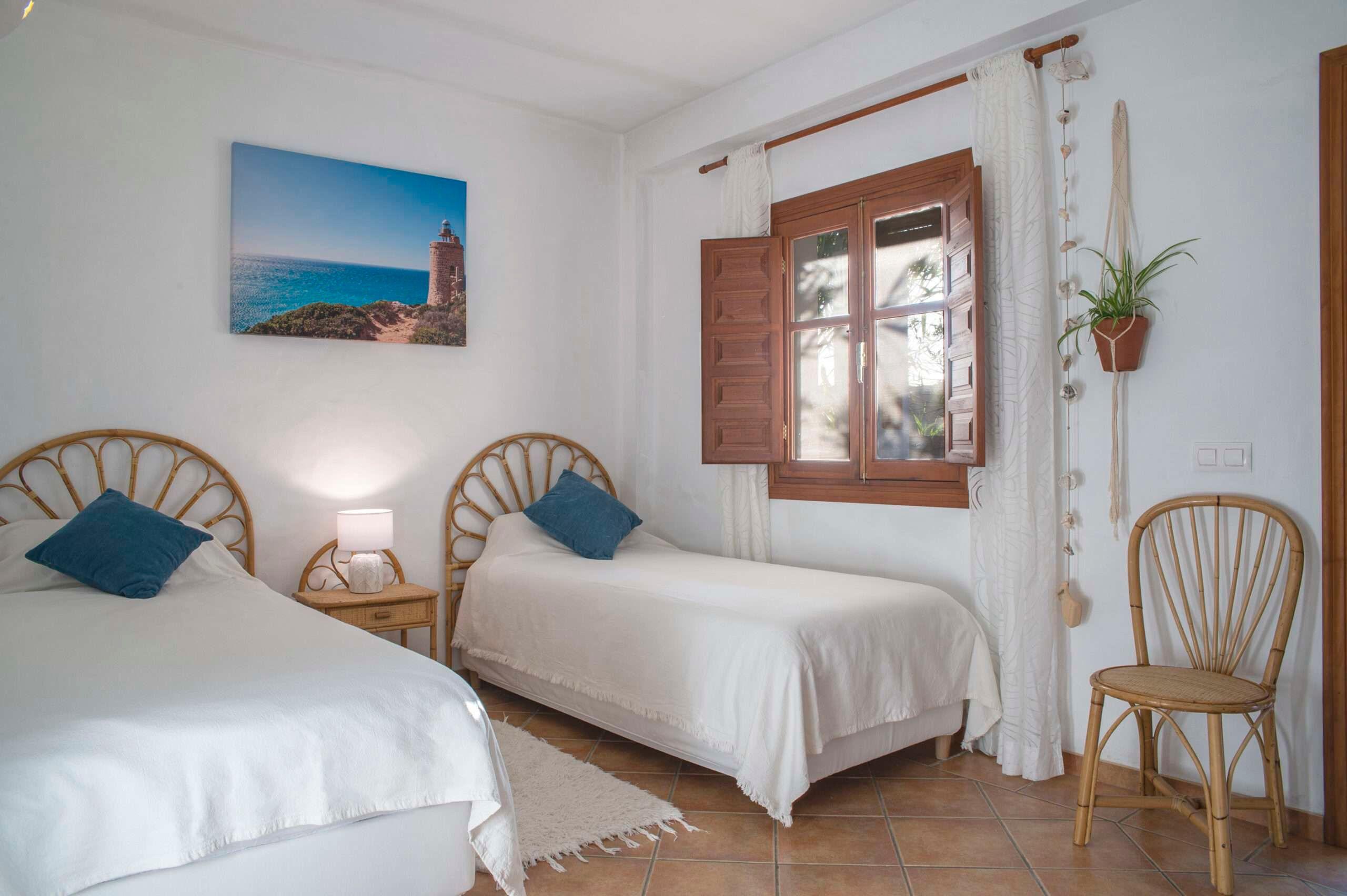 a room with 2 beds, a window and a fotograph of a lighthouse