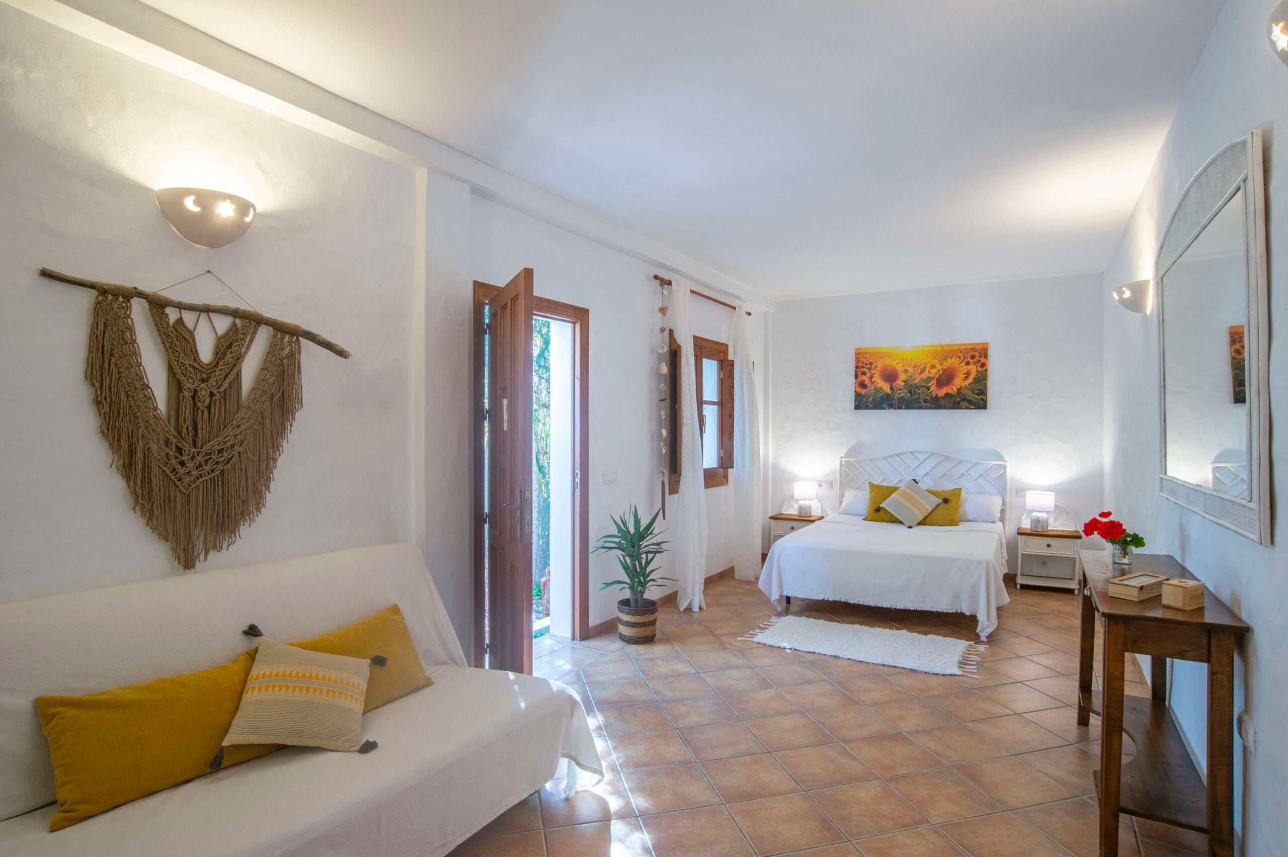 room with a bed and a sofa, the door open