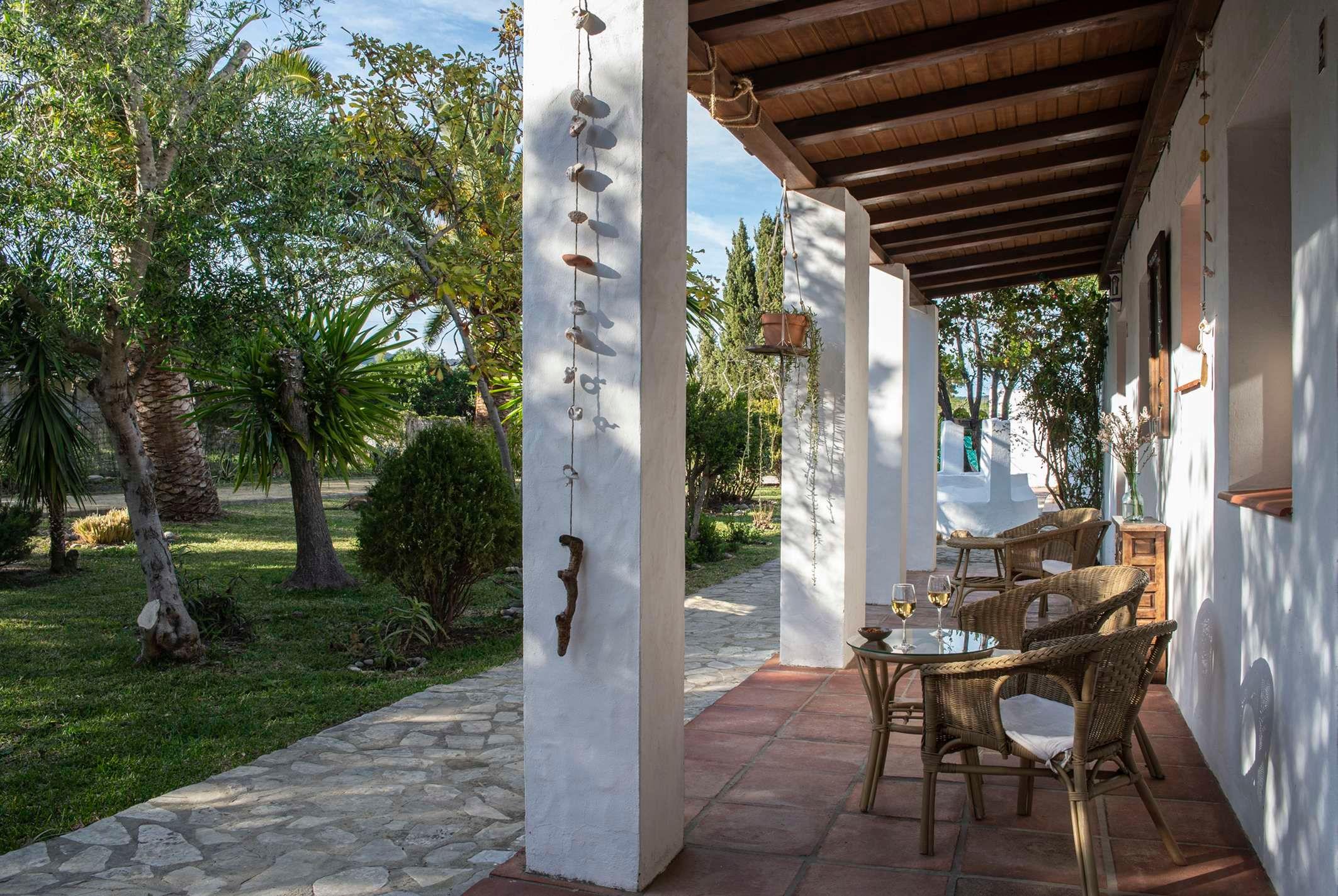 covered terrace with garden furniture, decoration and trees