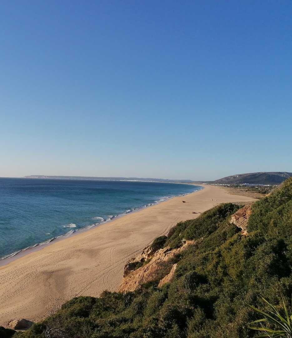 Panoramic view of a long sandy beach on the Costa de la Luz with clear blue sky