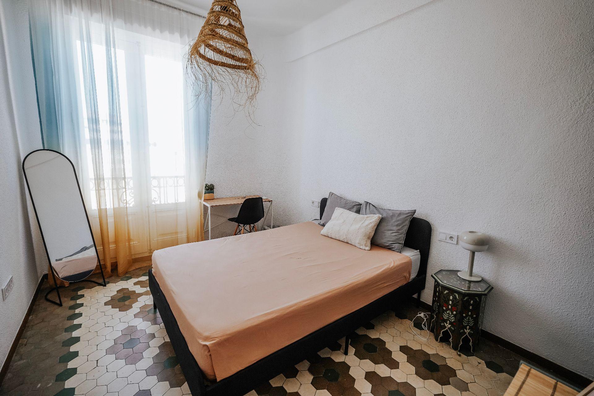 Private room with city view, small balcony, wardrobe, and desk