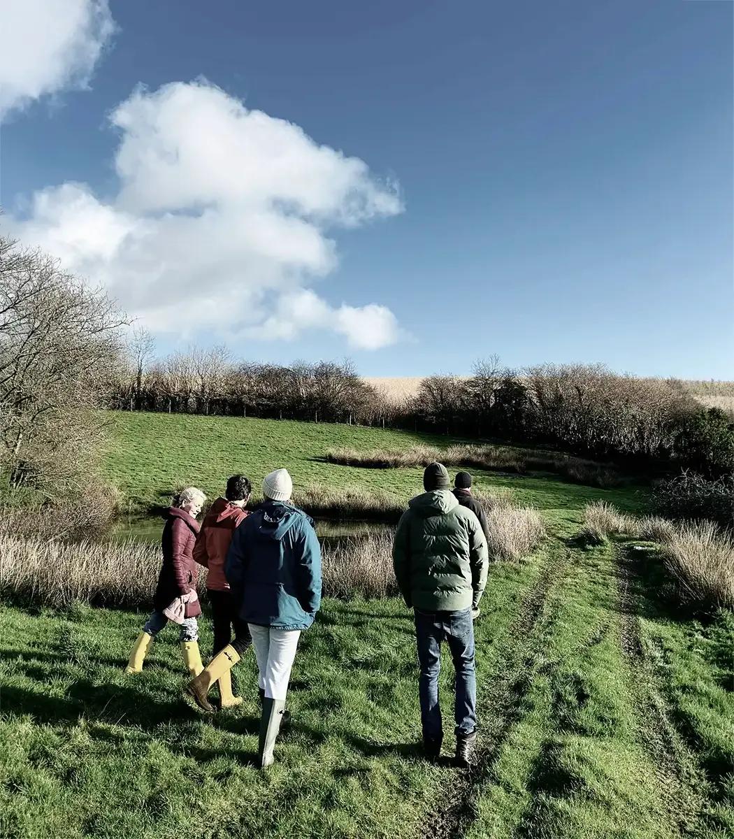 Group of Froomies residents walking through the countryside fields on the 80-acre farm