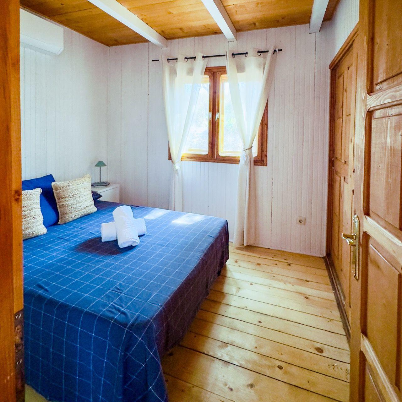 Private bedroom in a cabin with blue bedding and wood door