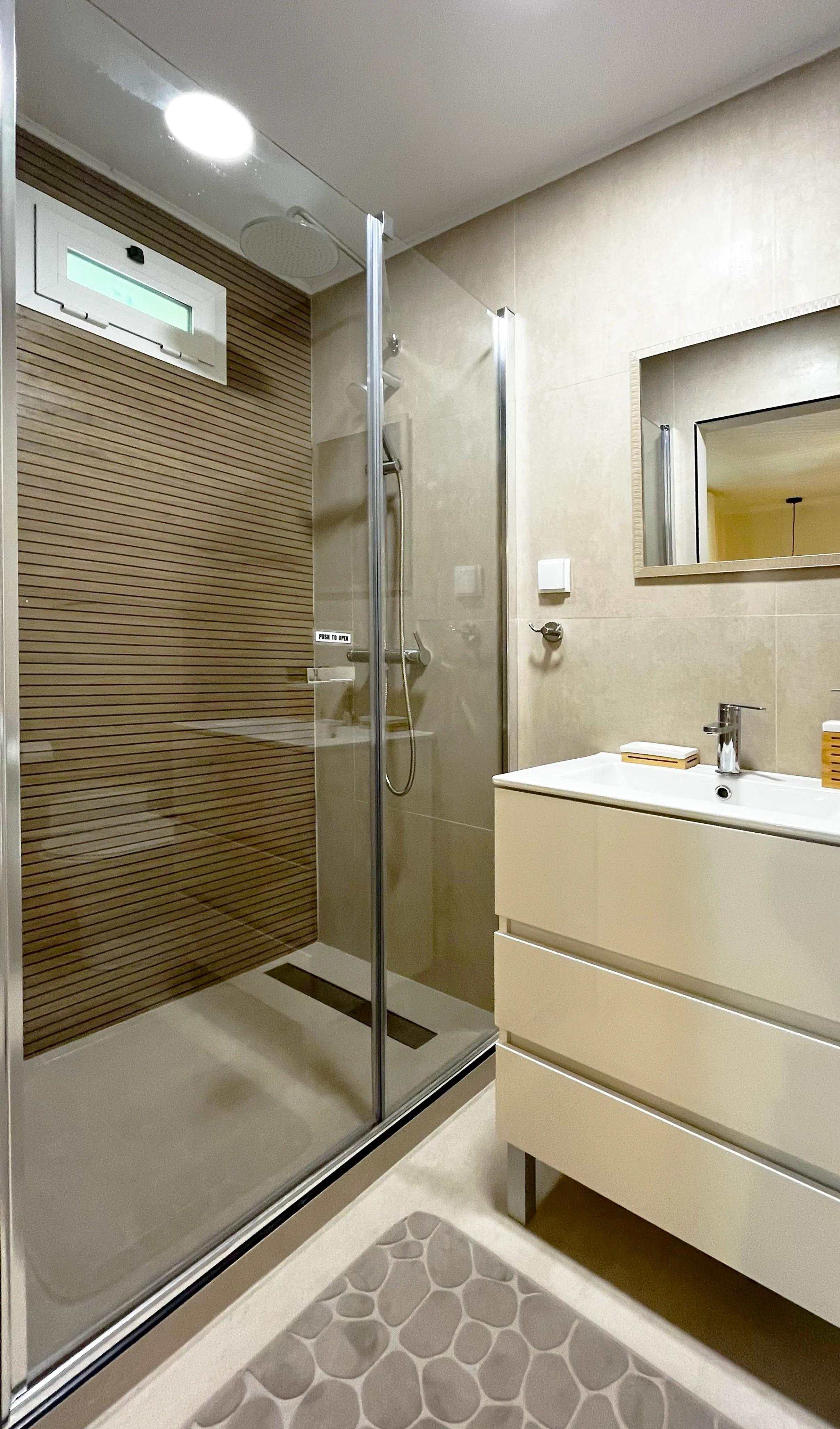 Private bathroom with glass shower enclosure in Room 02 Magnólia