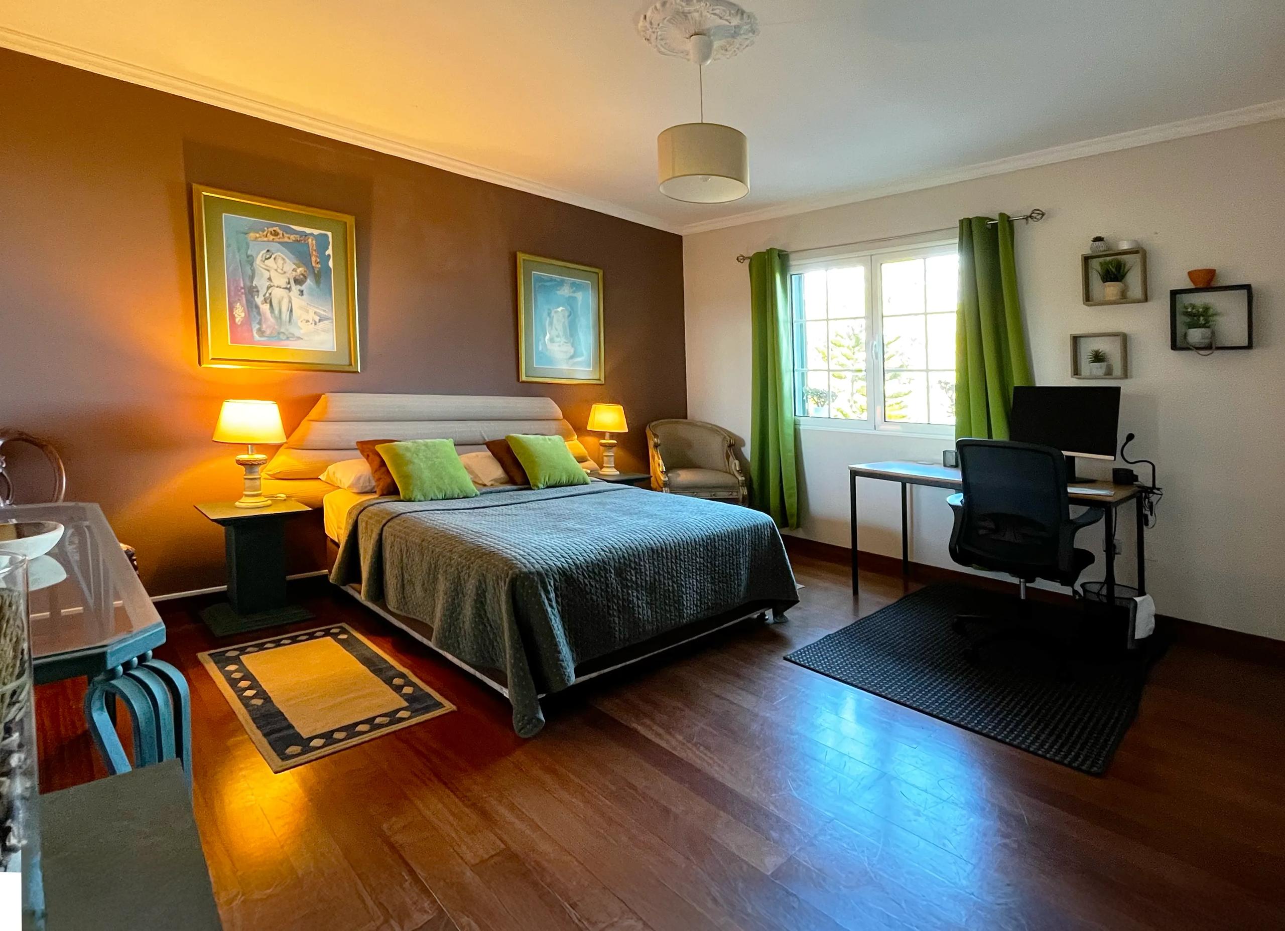 Premium double room with large bed, warm lighting, artwork and desk in Room 07 Girassol