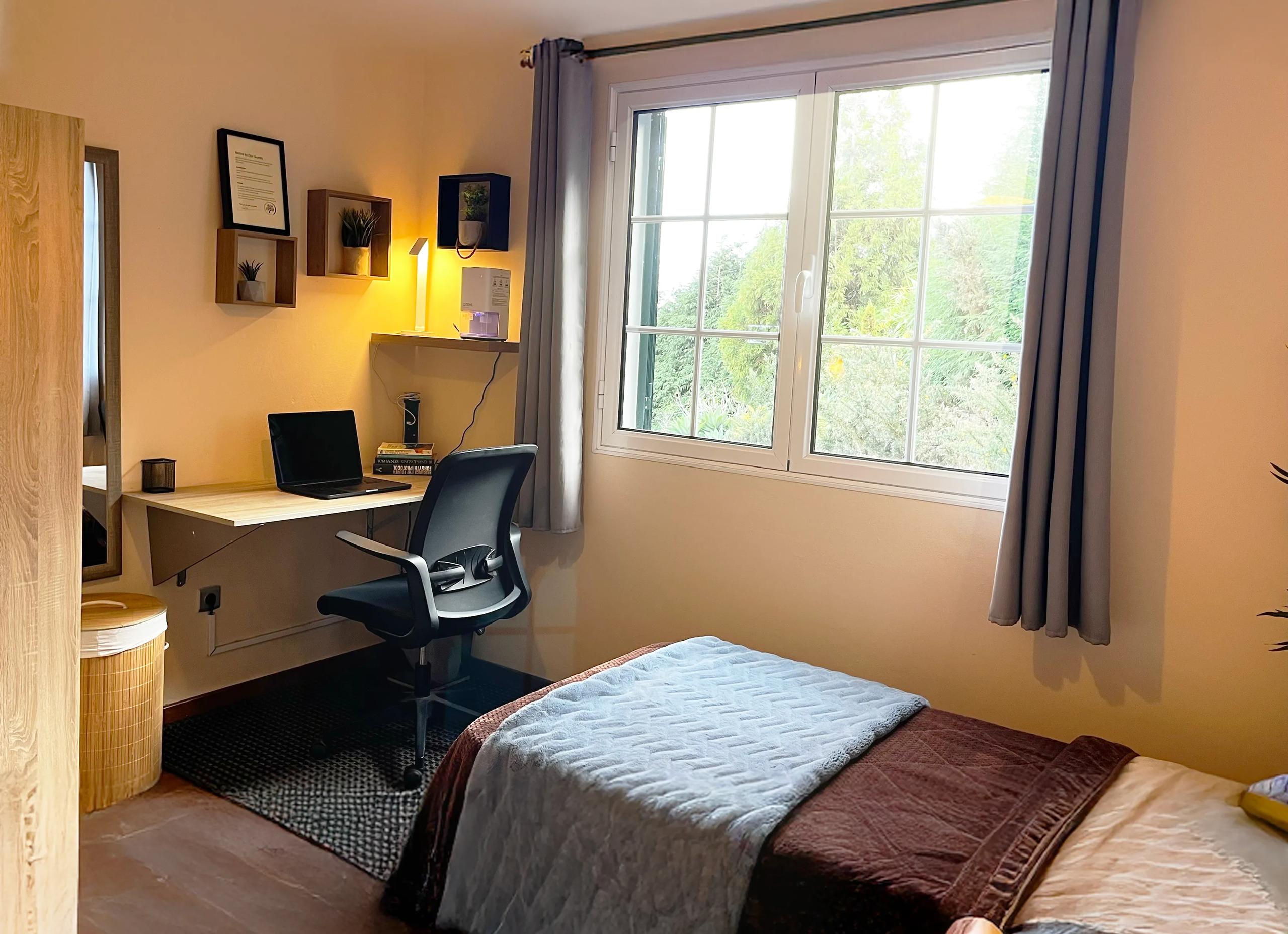 Twin room with desk, laptop and garden view window in Room 10 Malva
