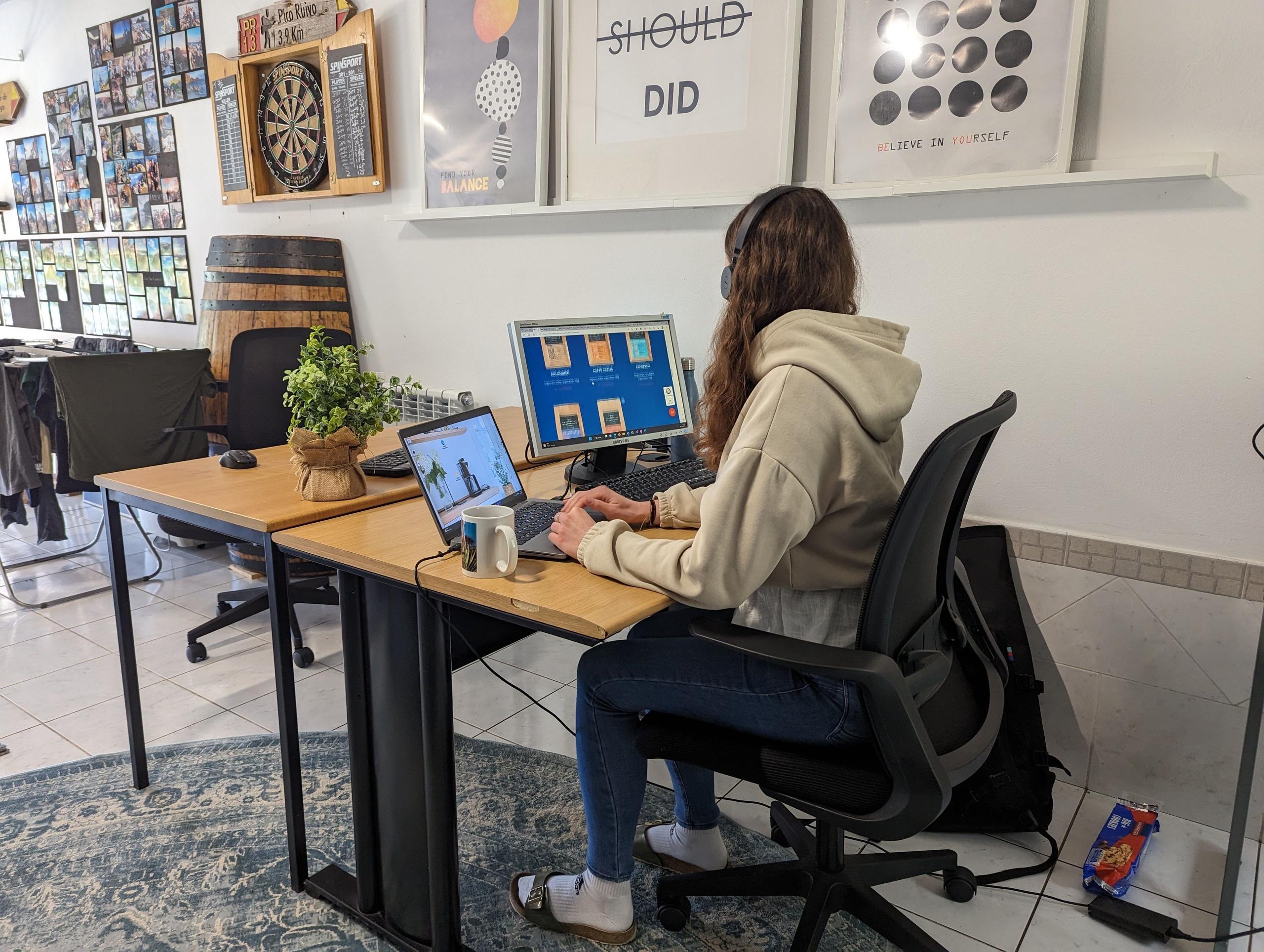 Alena, a guest at Homeoffice Madeira, works in the converted garage workspace, enjoying the calming view of the garden as she focuses on her tasks.