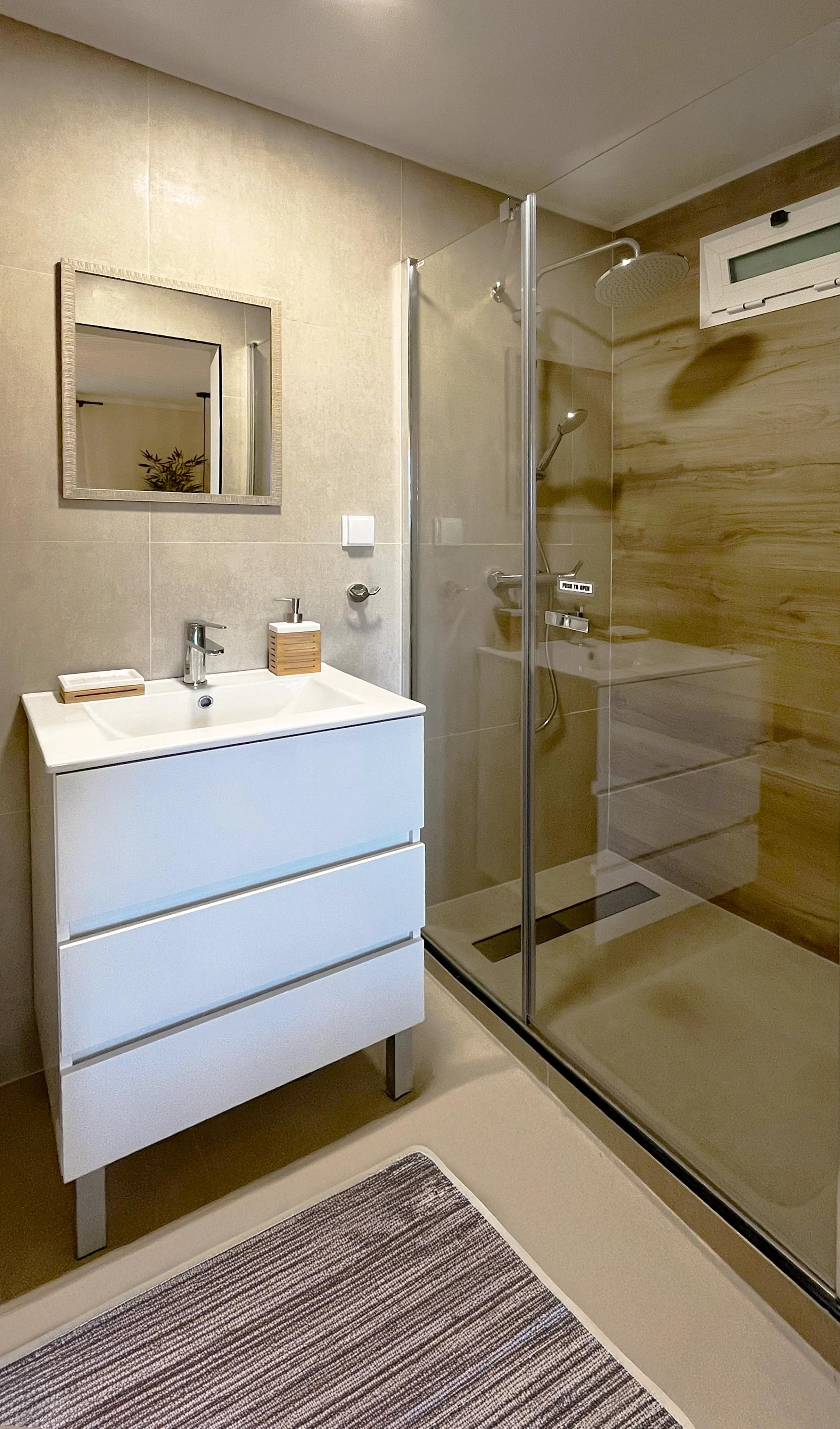 Private bathroom of Room 01 Gerânio with shower, vanity and mirror