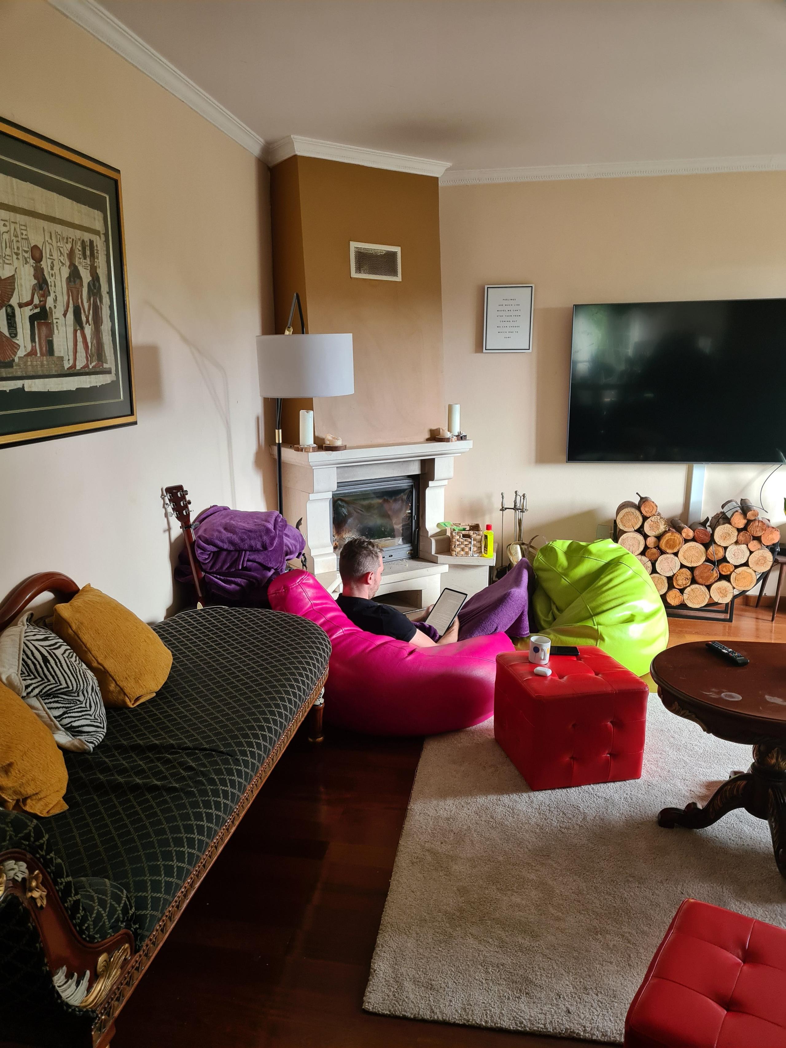 Guests relaxing in the living room with colorful chairs and a fireplace