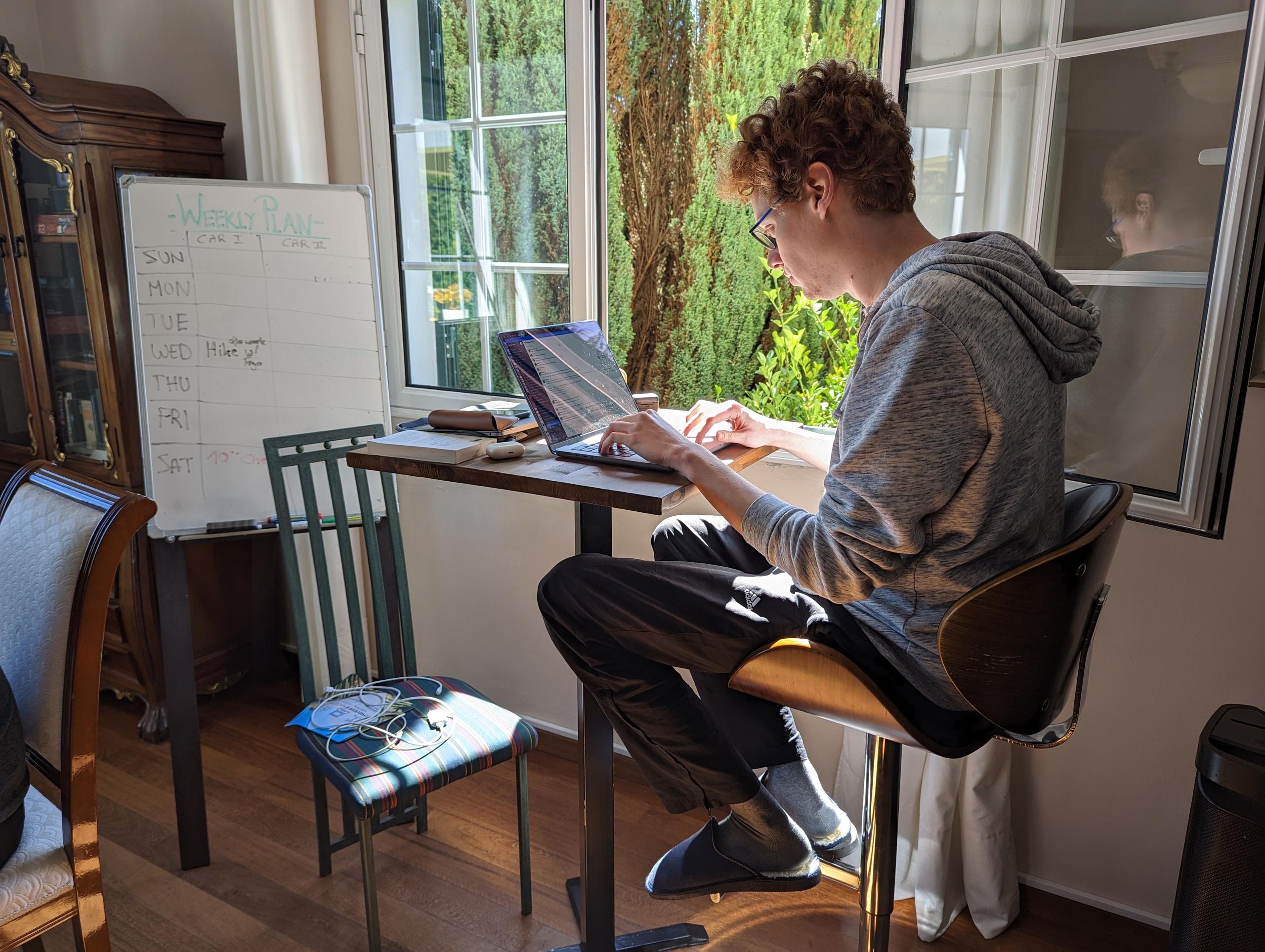 Simon working at the high table in the spacious and collaborative common area of Homeoffice Madeira