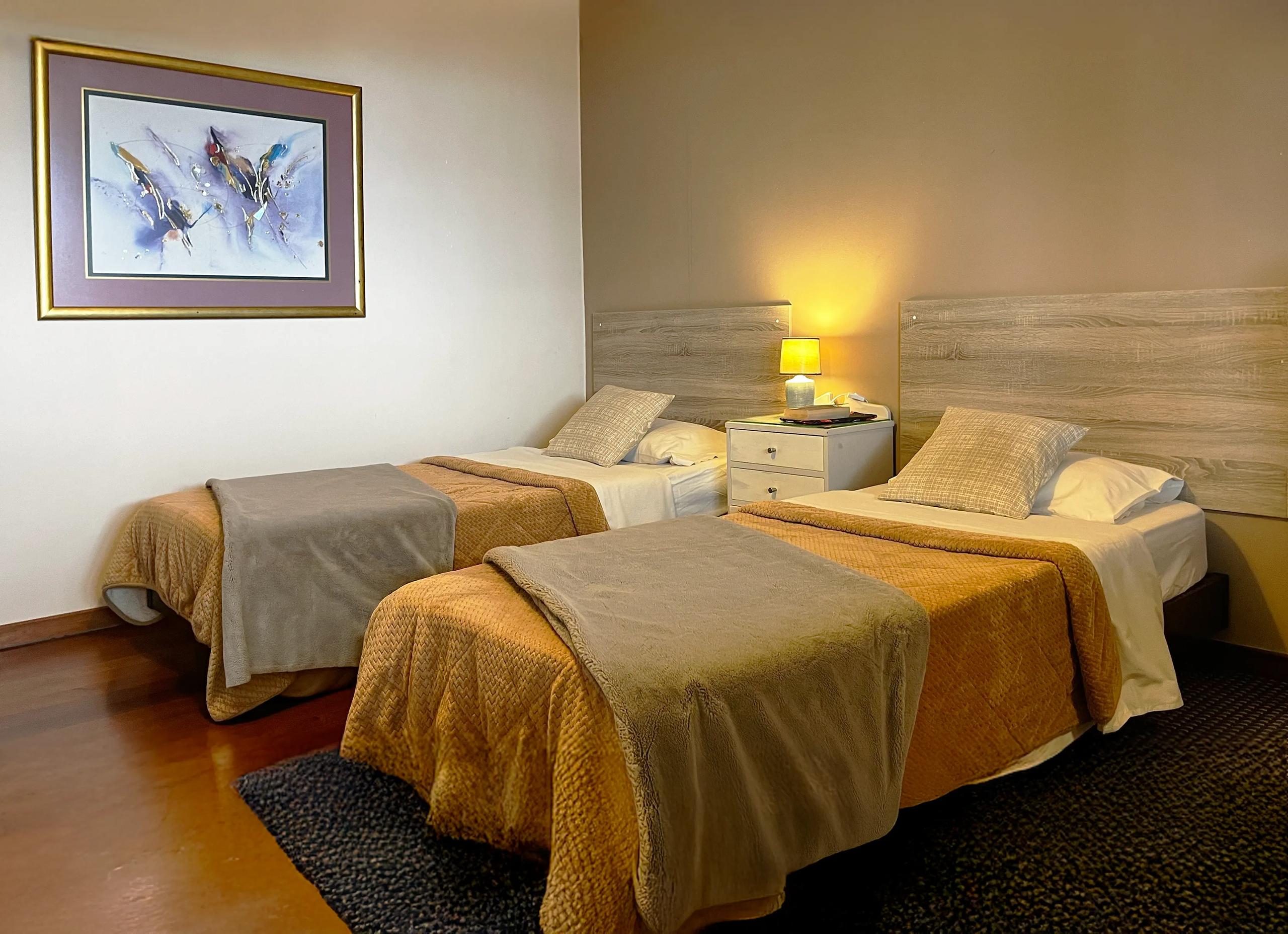 Twin room with two beds and artwork in Room 08 Protea