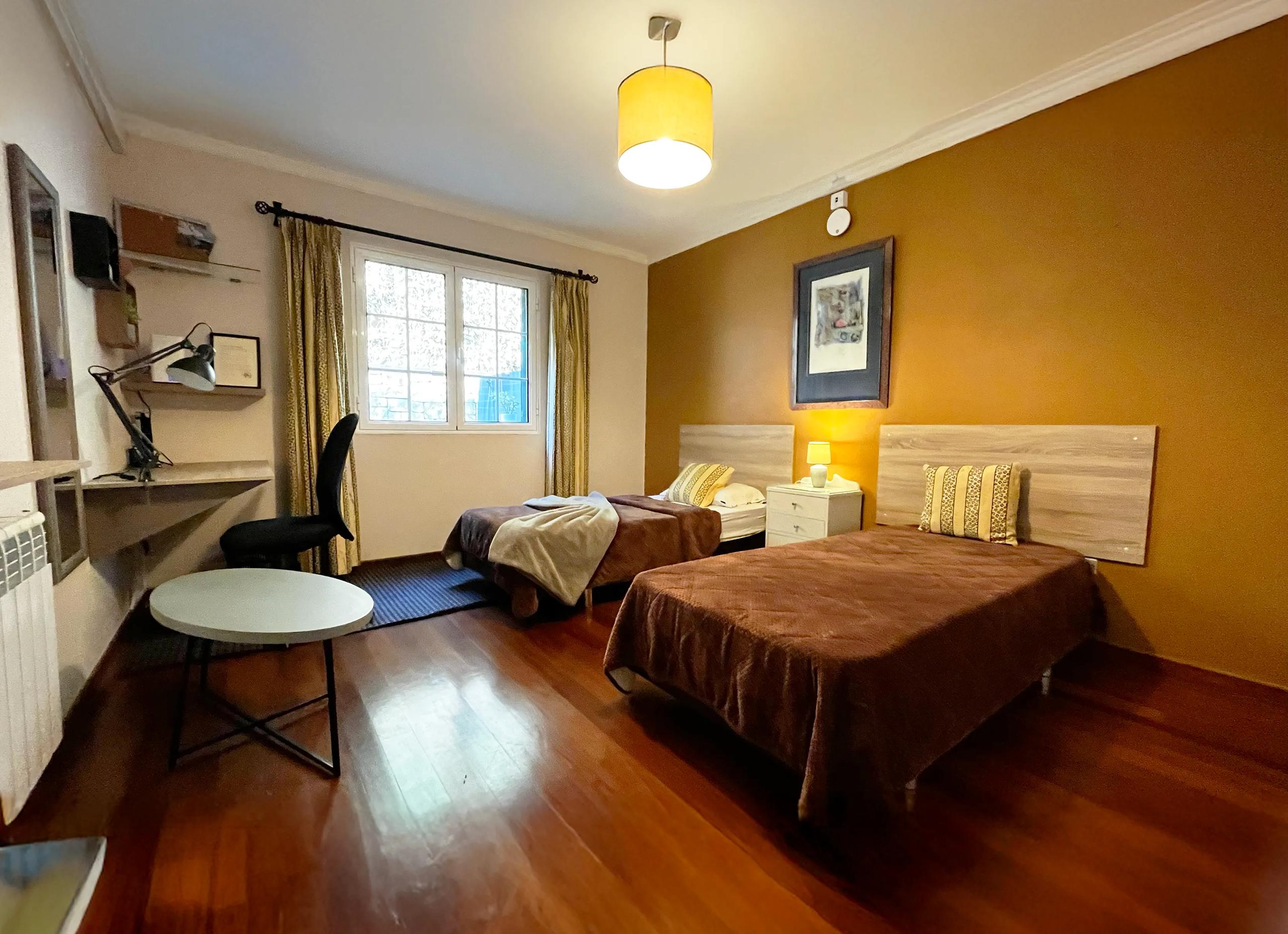 Twin room with two beds and warm lighting in Room 05 Azálea