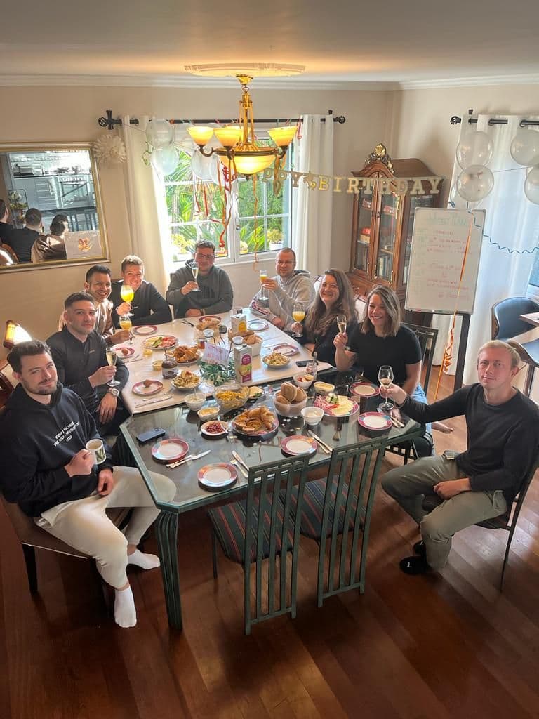 Homeoffice Madeira guests gather around the dining table to celebrate a fellow guest's birthday