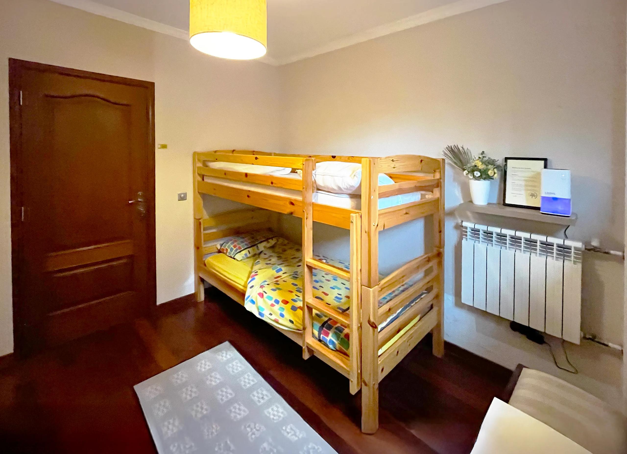 Bunk bed room with wooden bunk beds and radiator in Room 06 Camélia