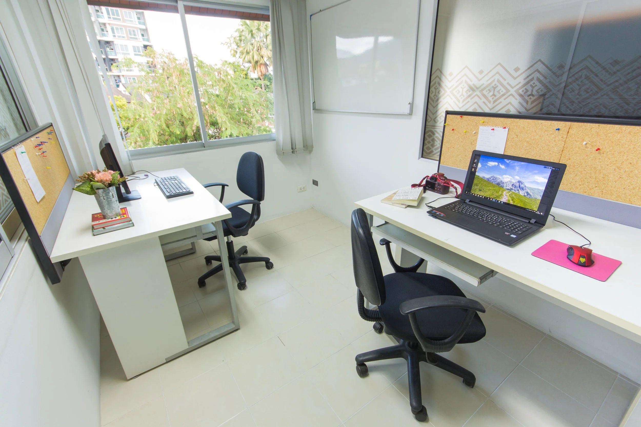 Medium private office with two desks, computers, chairs and whiteboard