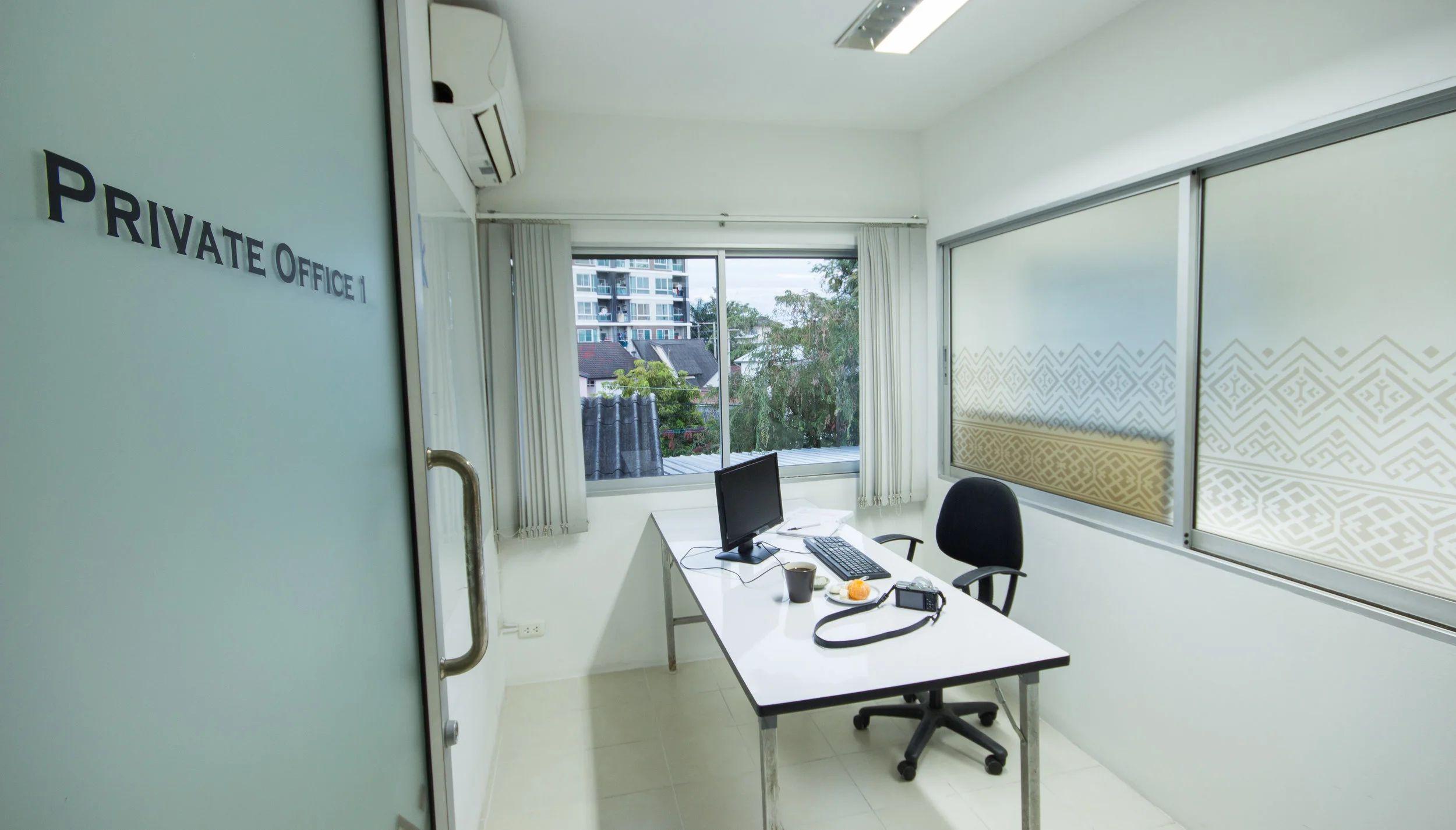 Private Office 1 with desk, computer, chair and frosted glass door with Private Office 1 label