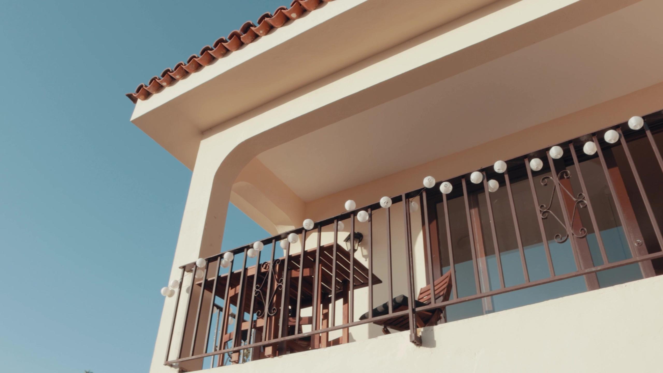 Exterior view of the Ikigai Coliving building showing the balcony facade against a blue sky