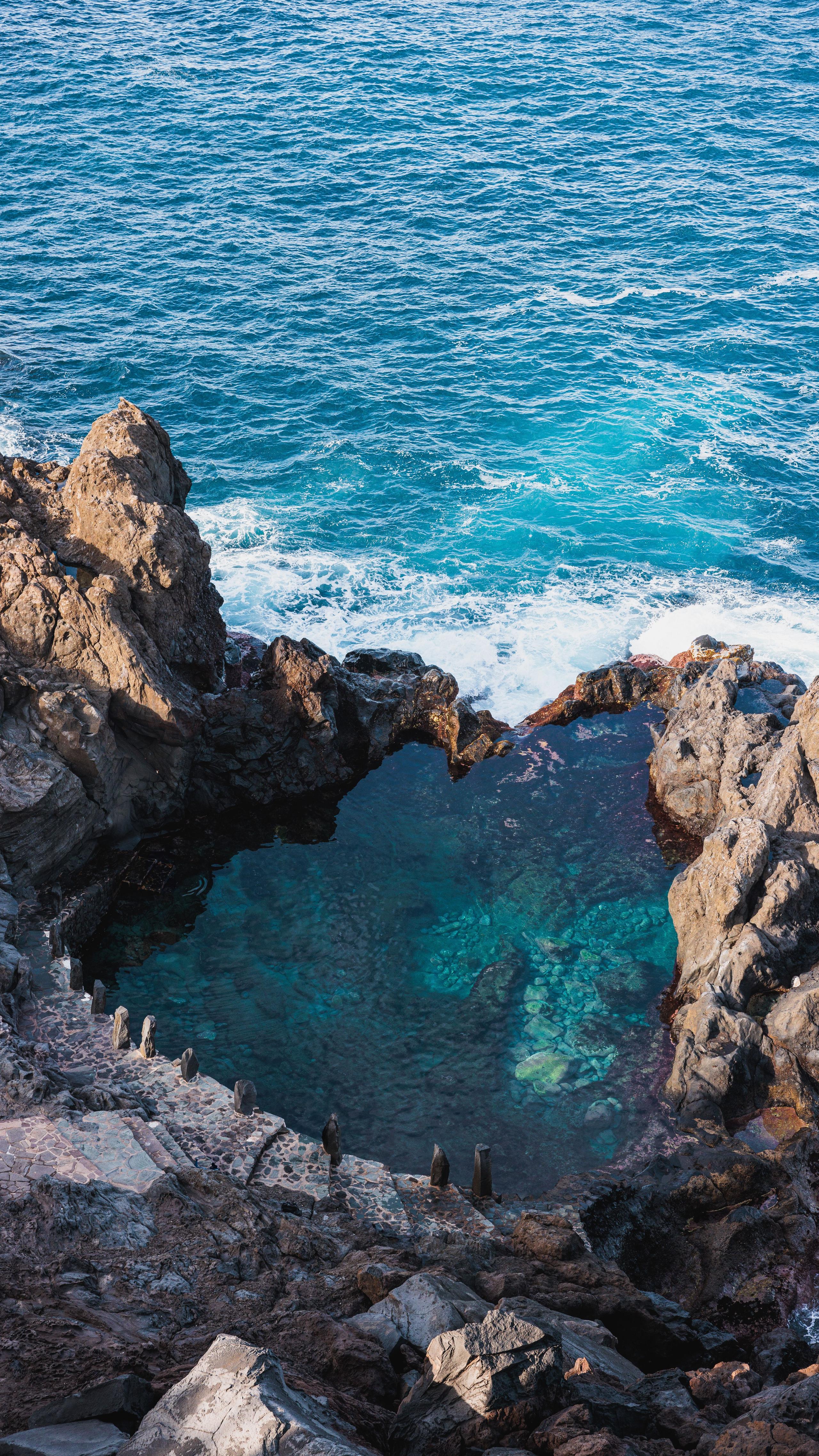 Natural volcanic rock pool with crystal clear turquoise water by the ocean