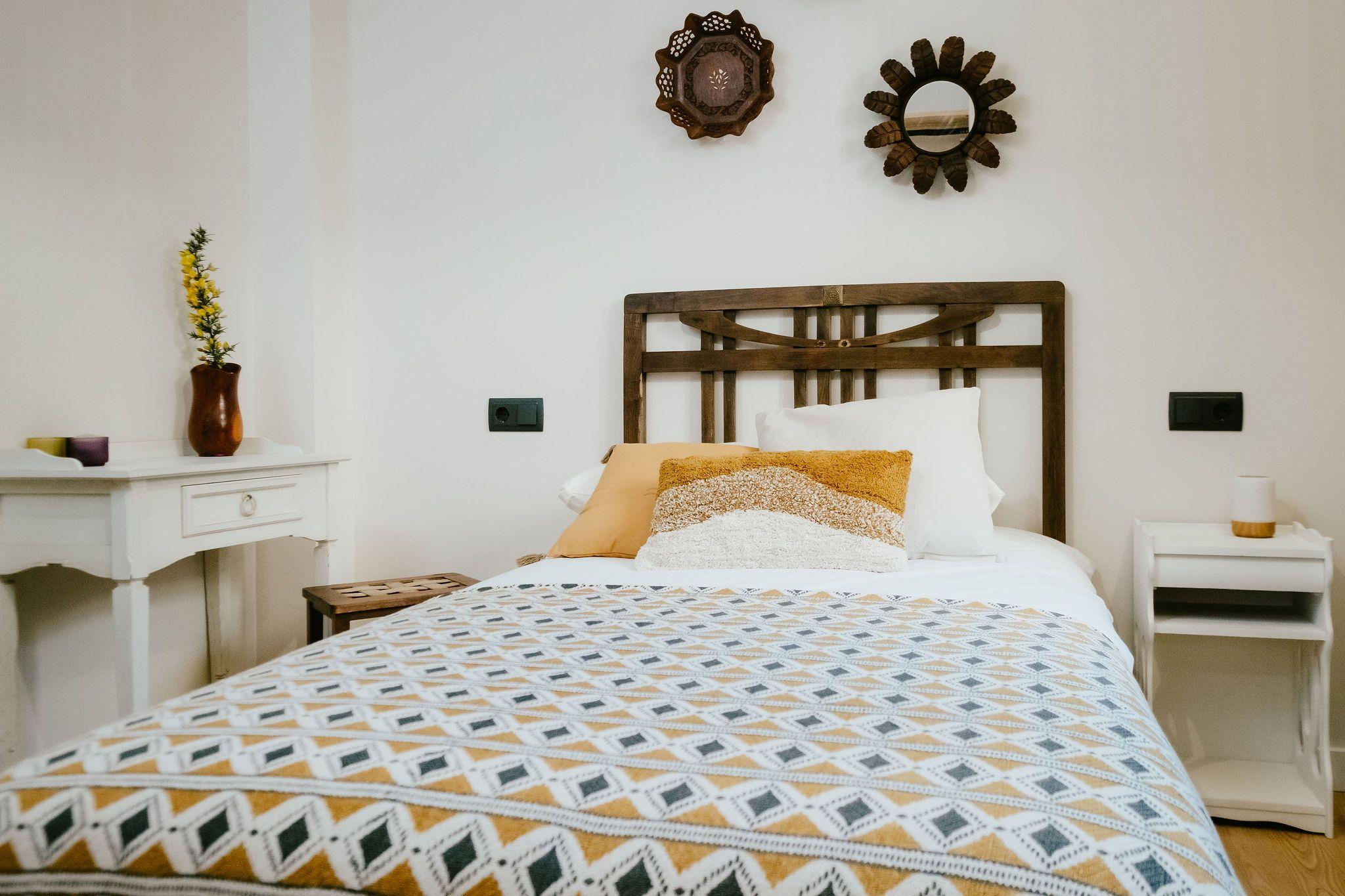 Single room A Eira with big single bed, wooden headboard, warm decor and decorative mirrors