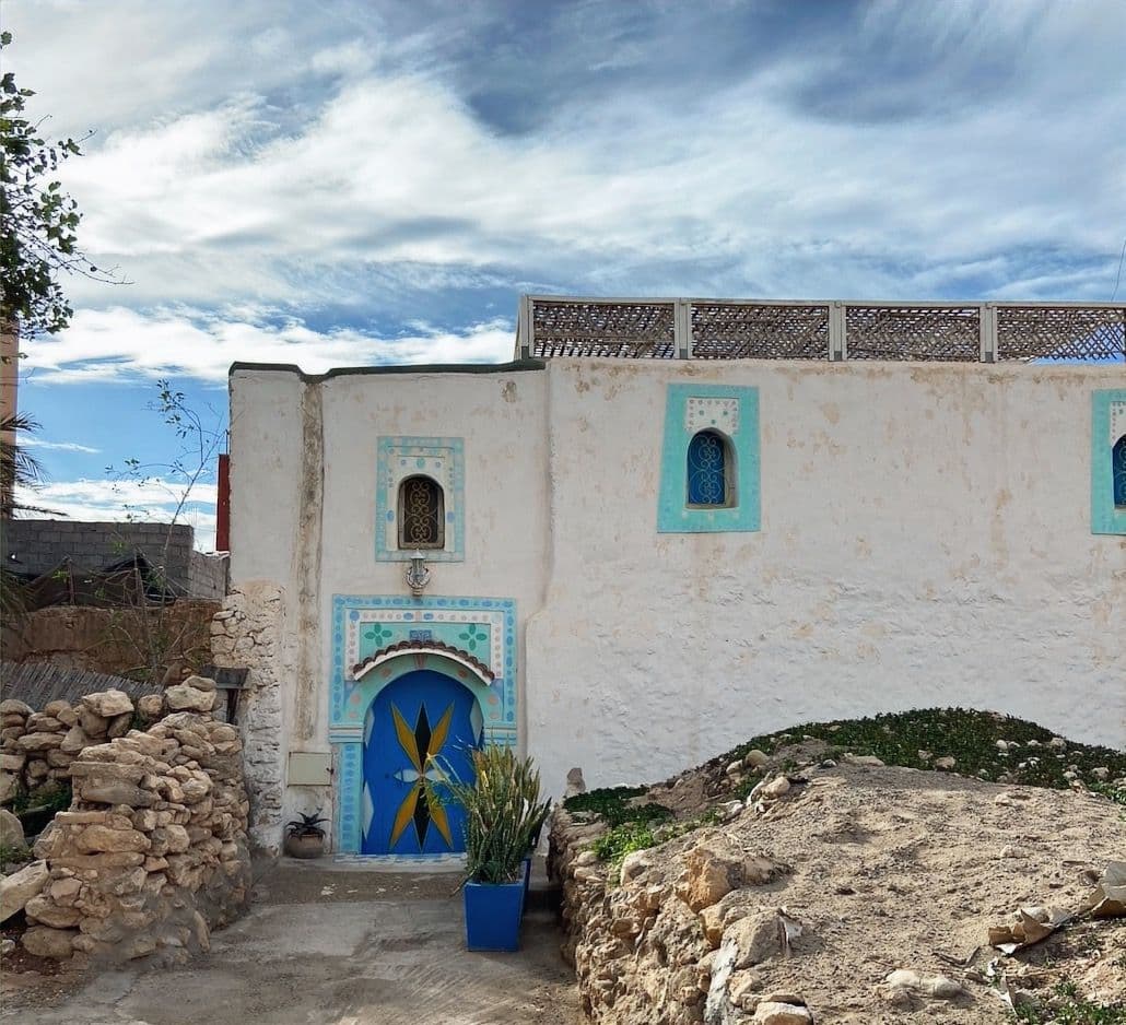 Traditional Moroccan house in Tamraght with blue painted door and decorative tile work