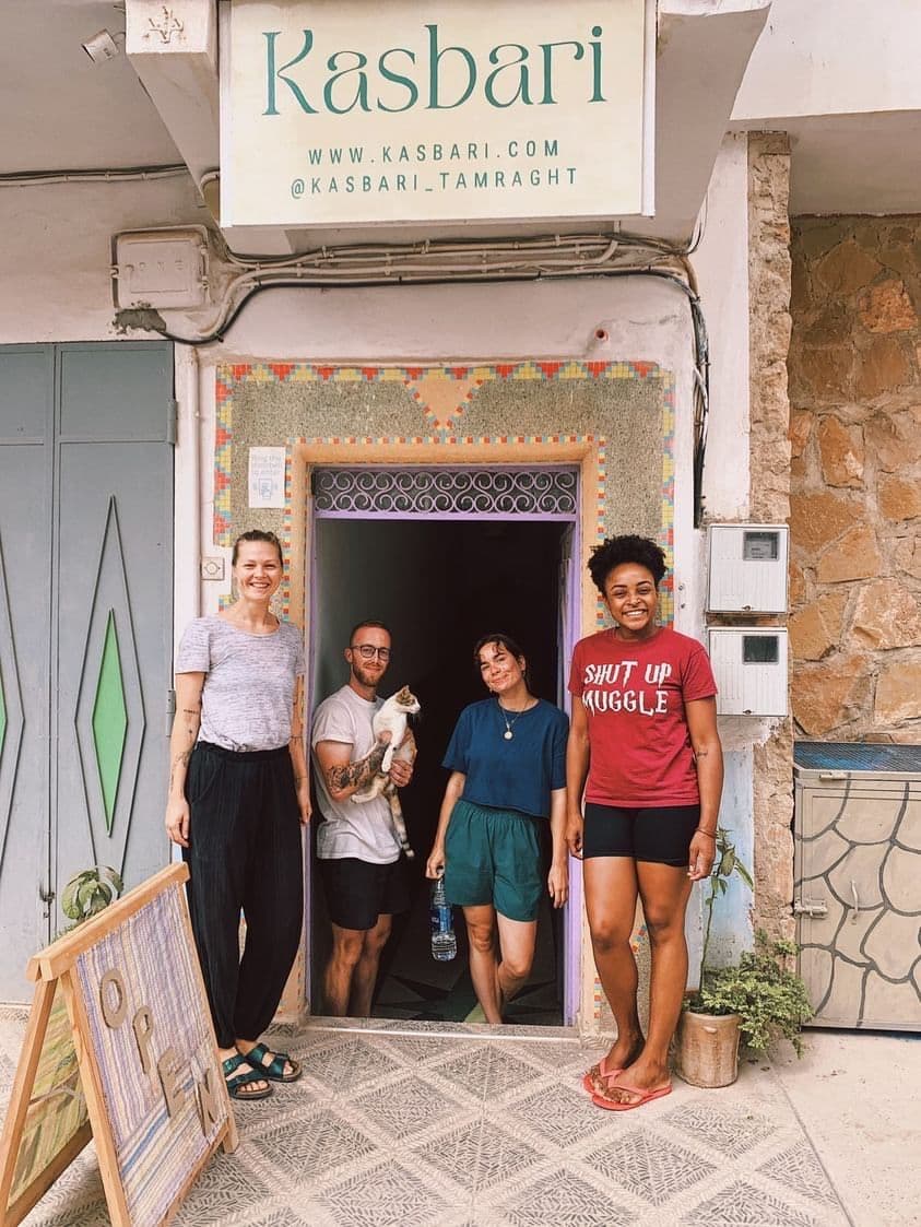 Group of people standing at the entrance of Kasbari, with the Kasbari sign visible above the door