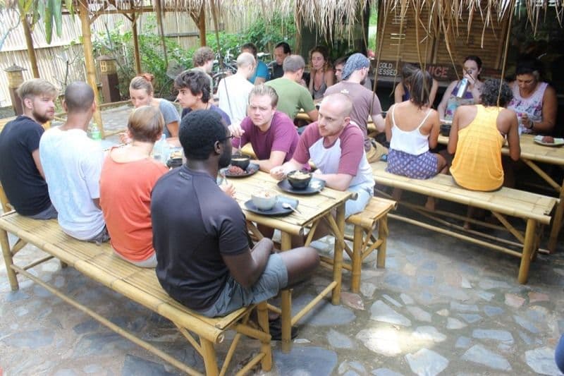 Large group of KoHub members eating together at communal lunch in The Shack outdoor area