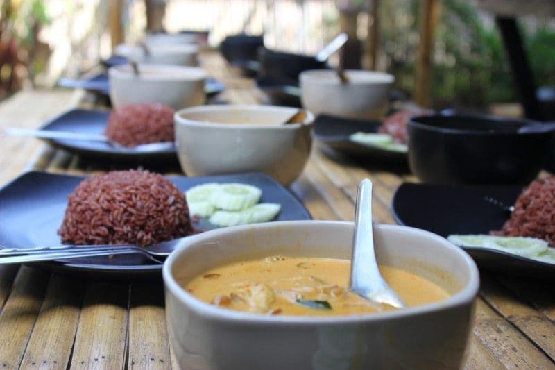 Thai curry and red rice served in bowls at a communal lunch