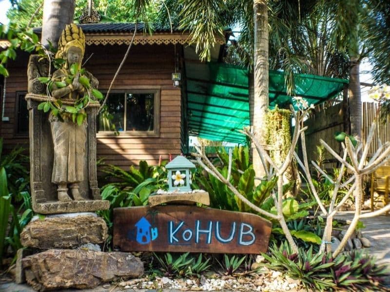 KoHub entrance sign with Thai statue and tropical garden at the entrance