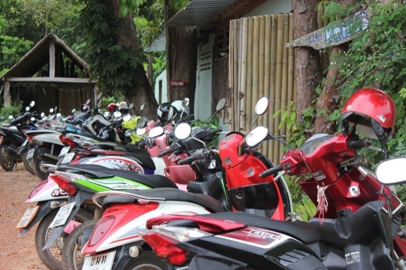 Row of scooters parked outside KoHub with the KoHub sign visible