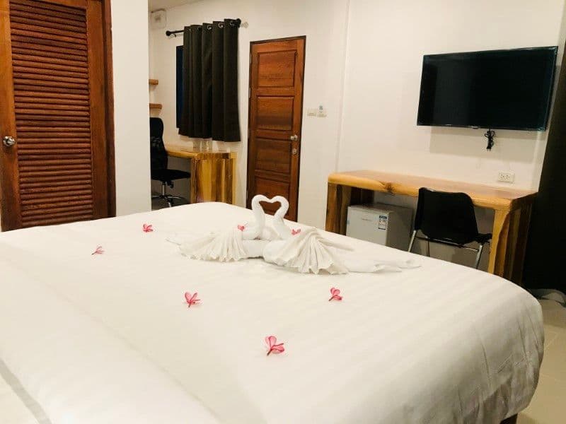 Private bungalow bedroom with king-size bed decorated with flower petals, Smart TV, working desk and ergonomic chair