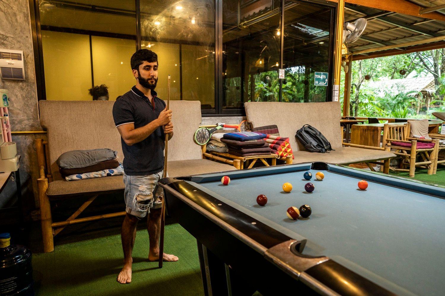 Member playing pool at the pool table in The Shack social area