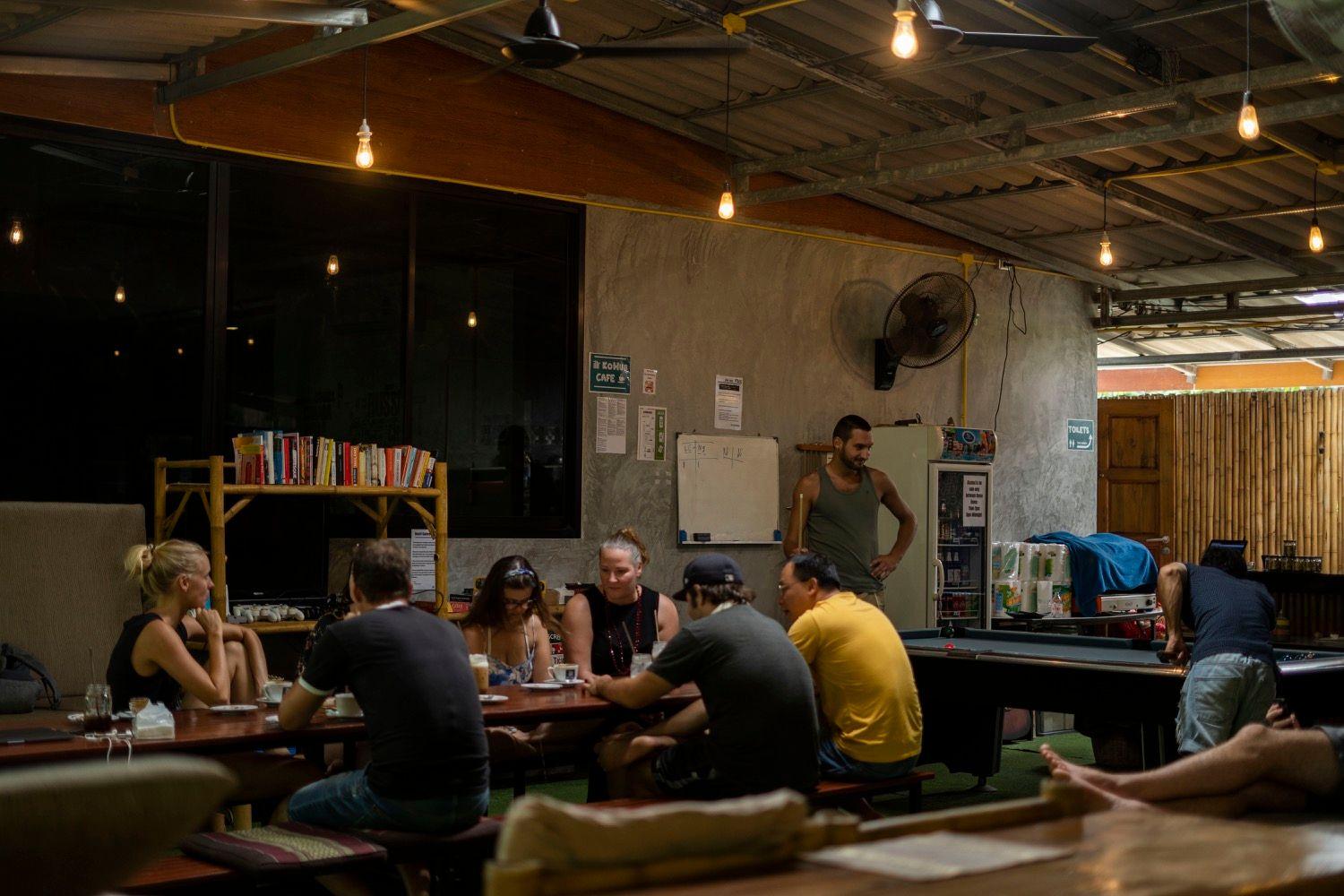 Group of members gathered around a table in the evening at KoHub social area