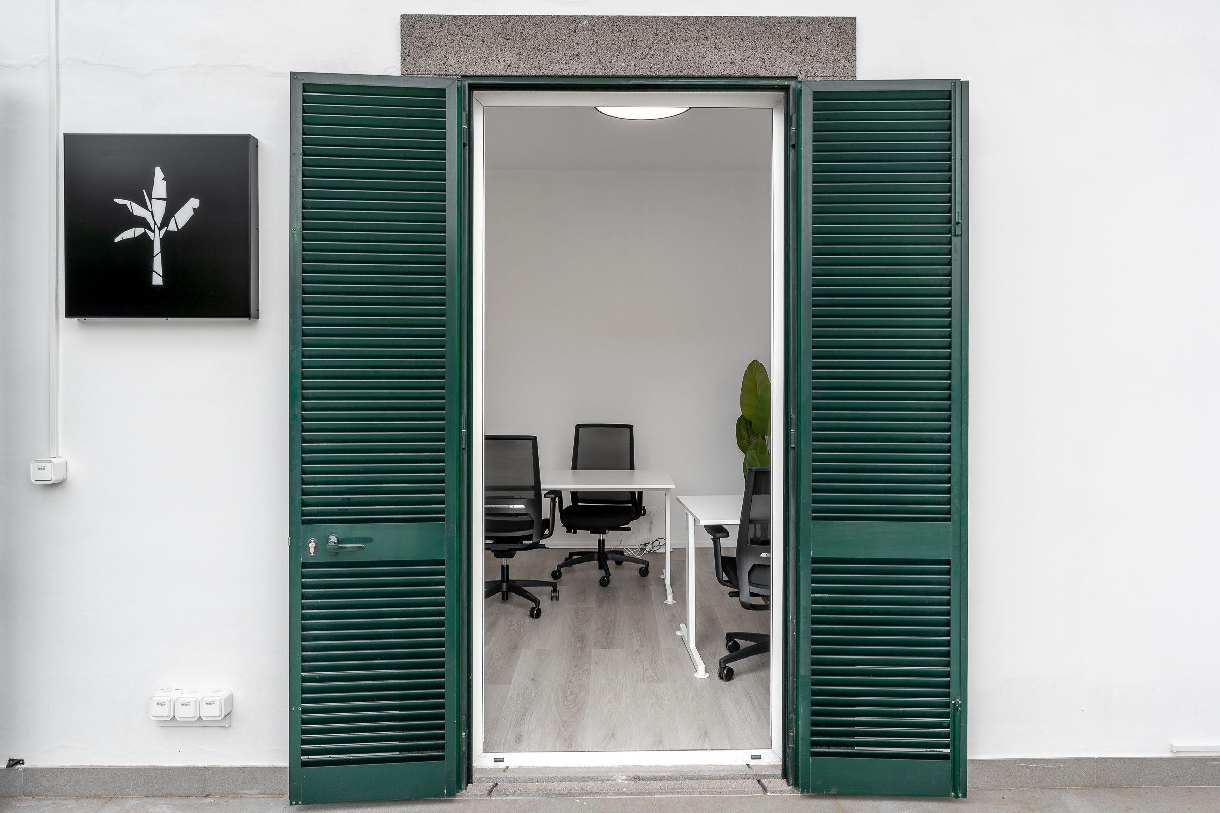 Entrance to meeting room at Madeira Friends Hub with green shuttered double doors and Madeira Friends logo sign