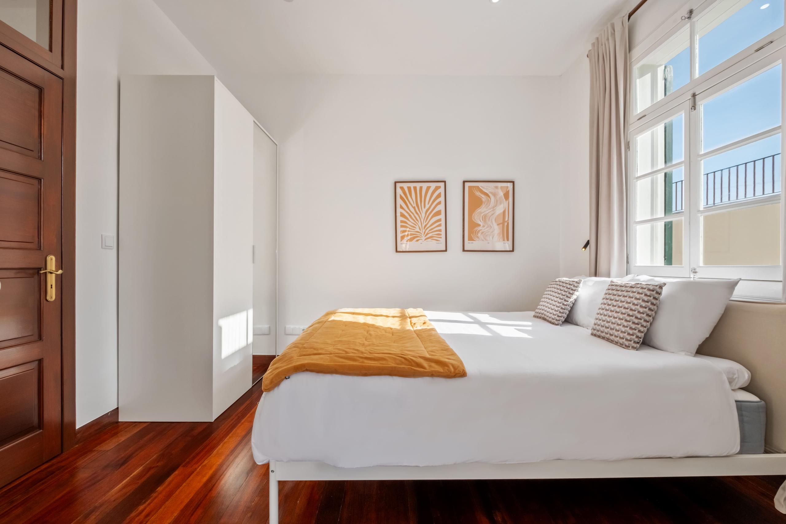 Protea room wide angle showing queen bed, wardrobe, artwork, and window with curtains