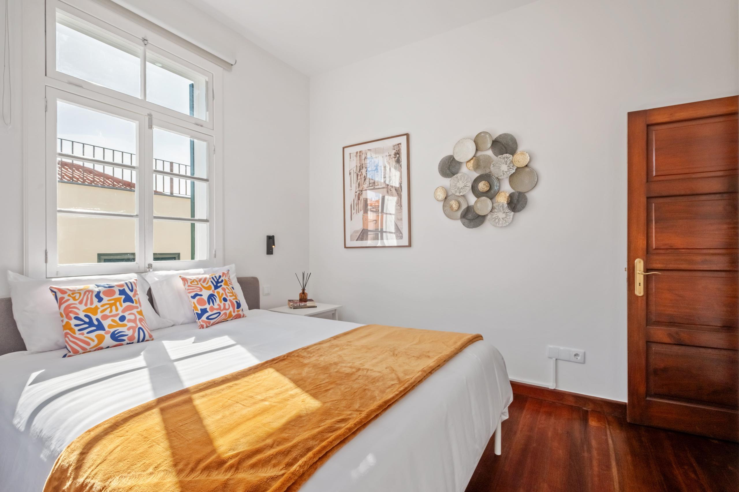 Buganvília room wide angle showing queen bed, windows, and wall art