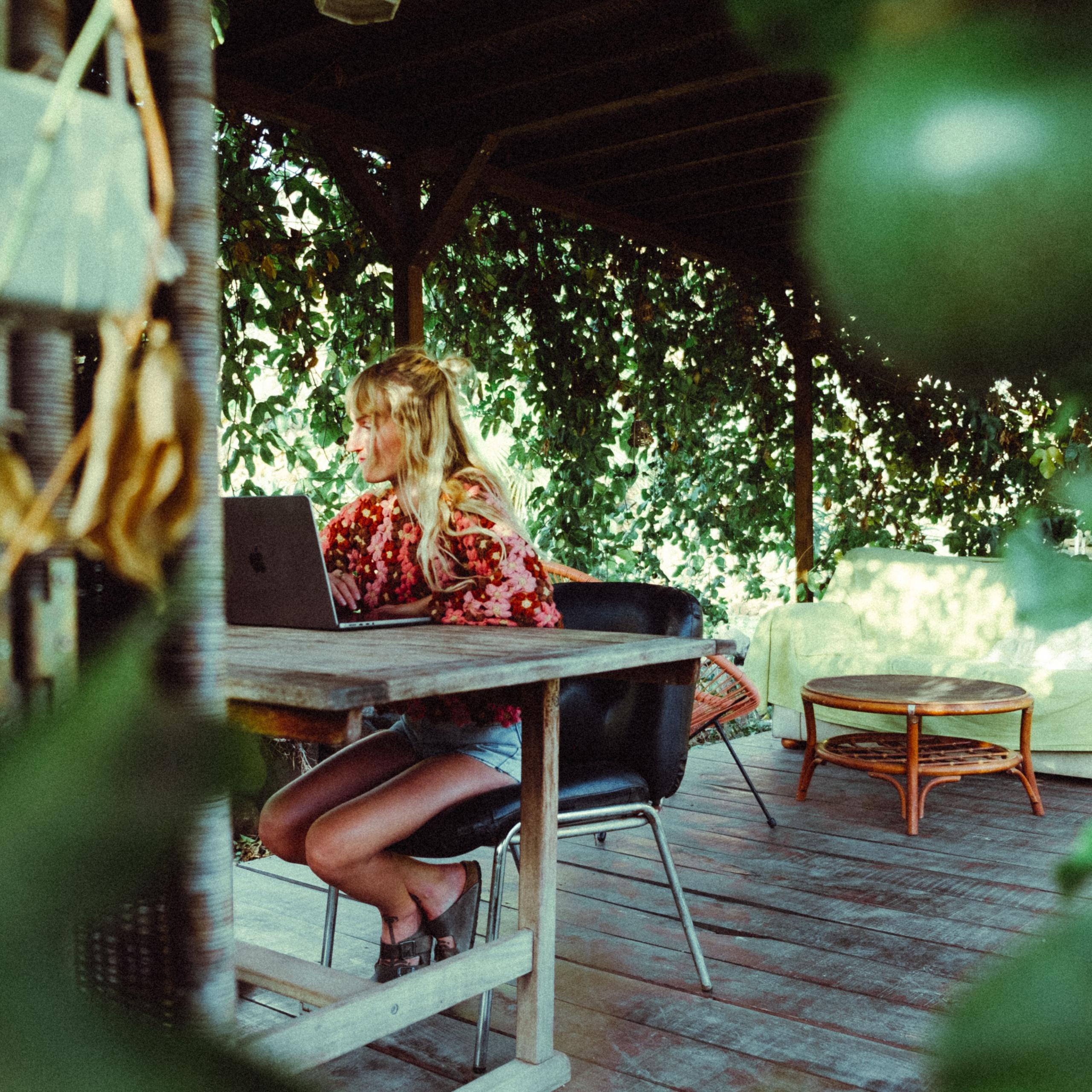 Person working in The Pergola, the outdoor office nestled at the front of the garden at Maraya Coliving