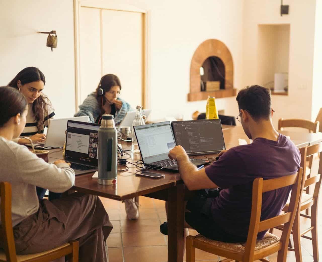 Remote workers using laptops in a coworking space at a coliving in Italy