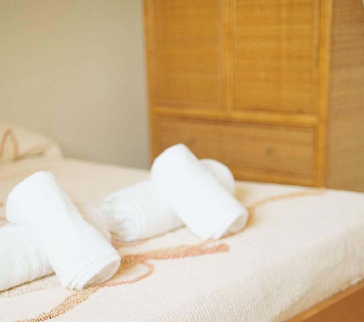 Ensuite room with bed and towels at Masseria Olga coliving in Italy