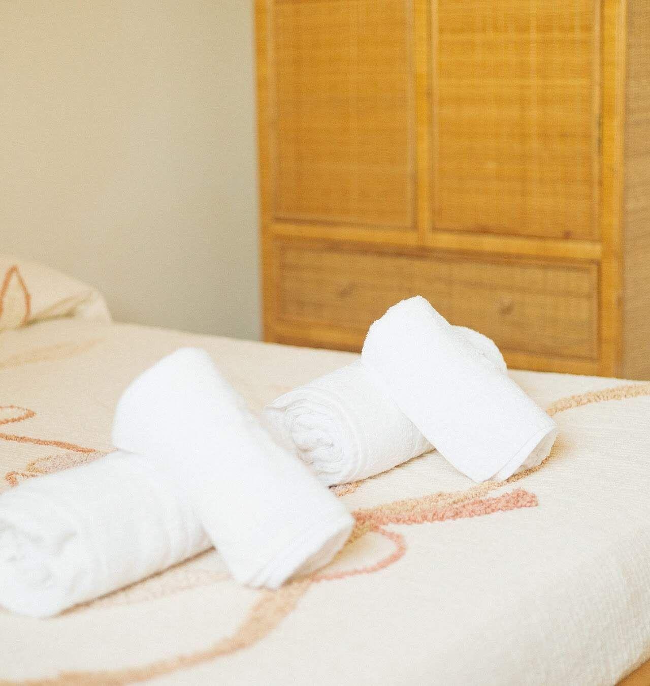 Ensuite room with a dedicated office space and fresh white towels at Masseria Olga coliving in Italy