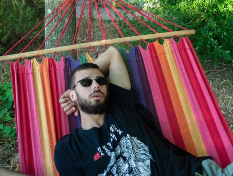 Digital nomad relaxing on a hammock in the garden of Masseria Olga coliving in Puglia, Italy – part of the coliving community lifestyle